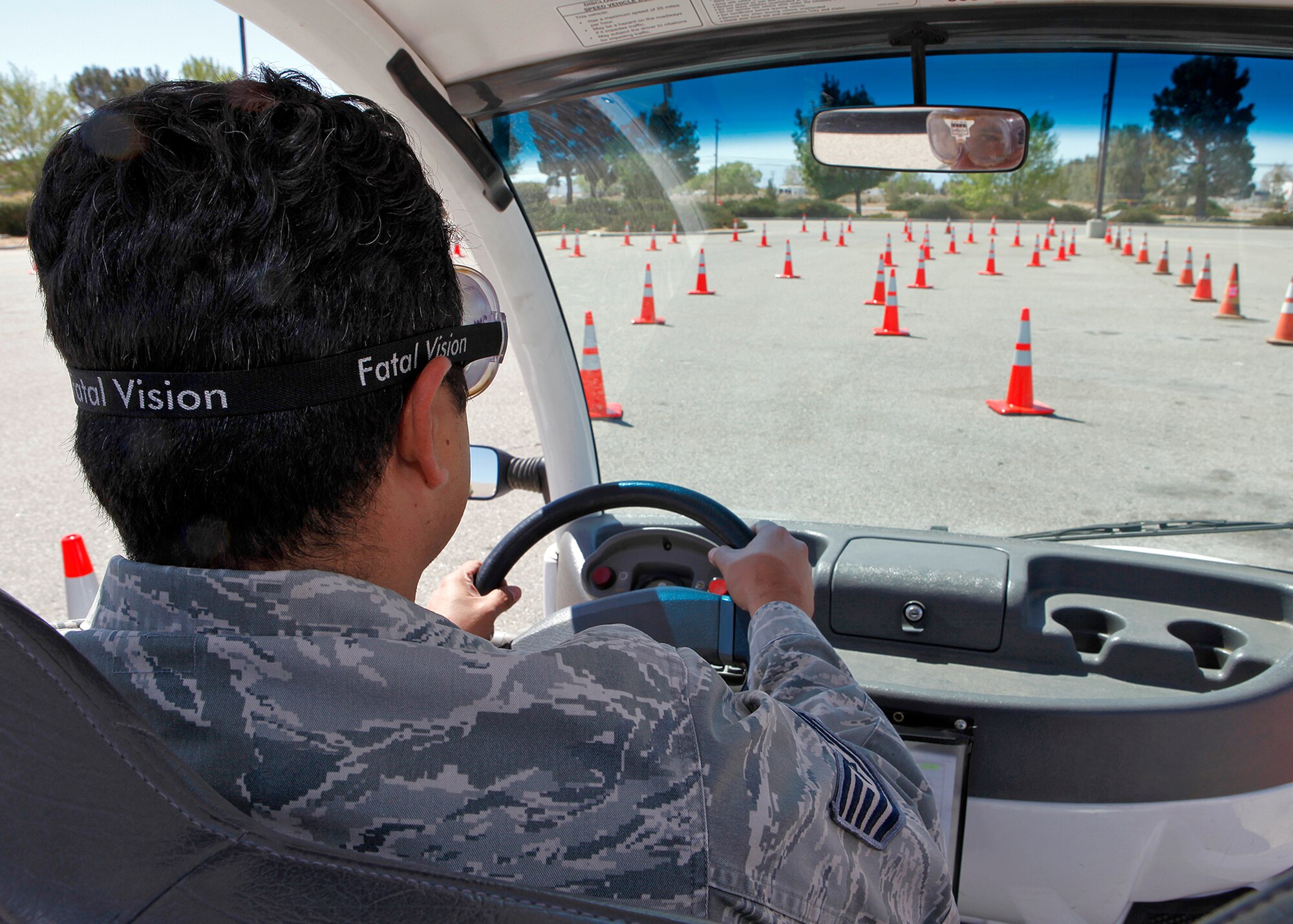 Tech. Sgt. Matthew Flores, 412th Test Wing Ground Safety Office ground safety specialist, attempts to drive through a demonstration course while wearing goggles that replicate the effects of alcohol during an Alcohol Awareness Month event April 18 in the Base Exchange parking lot. (U.S. Air Force photo by Jet Fabara)