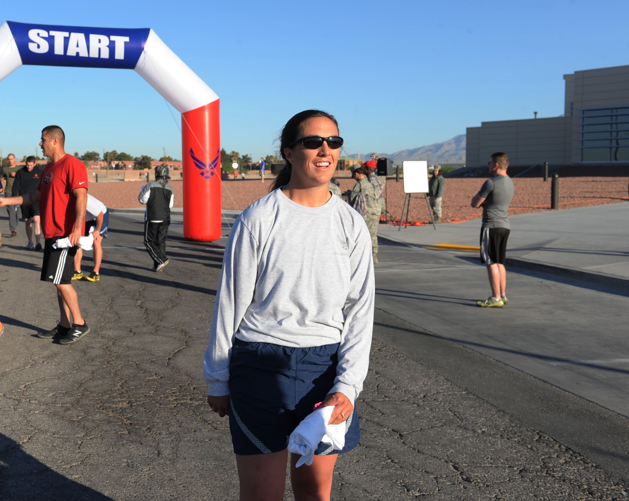 Christine Phillips, 820th RED HORSE Squadron airborne engineering craftsman and first female to finish the Survive and Thrive 5-kilometer run, stands by the finish line in front of the Warrior Fitness Center April 19, 2013, at Nellis Air Force Base, Nev. The run was organized to raise awareness of sexual assault prevention programs and mental health courses offered to Nellis Airmen.  (U.S. Air Force photo by Benjamin Newell)  