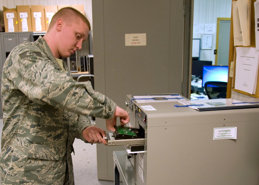 Staff Sgt. Brandon Talmadge, 436th Communications Squadron NCO in charge of client systems, explains how the degausser destroys the inner workings of hard drives bar April 16, 2013, at Dover Air Force Base, Del. Talmadge ships hard drives and other computer parts to Defense Logistics Agency Disposal Disposition Services to be recycled for parts and to be used in other computers.(U.S. Air Force photo/Senior Airman Jared Duhon)

