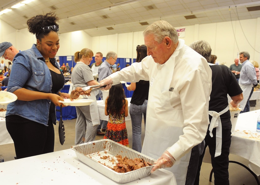 Lou Paulsen, right, serves Senior Airman Jazmin Beal, 7th Logistics Readiness Squadron, during the World’s Largest Barbeque April 20, 2013, at the Abilene Civic Center in Abilene, Texas. More than 150 volunteers from the Abilene Chamber of Commerce Military Affairs Committee, as well as Junior Reserve Officer Training Corps students from Abilene High School, helped set-up the event and serve food to approximately 4,000 active-duty, reservists, national guard, Department of Defense civilian personnel and their families. (U.S. Air Force photo by Senior Airman Cierra Presentado/Released)