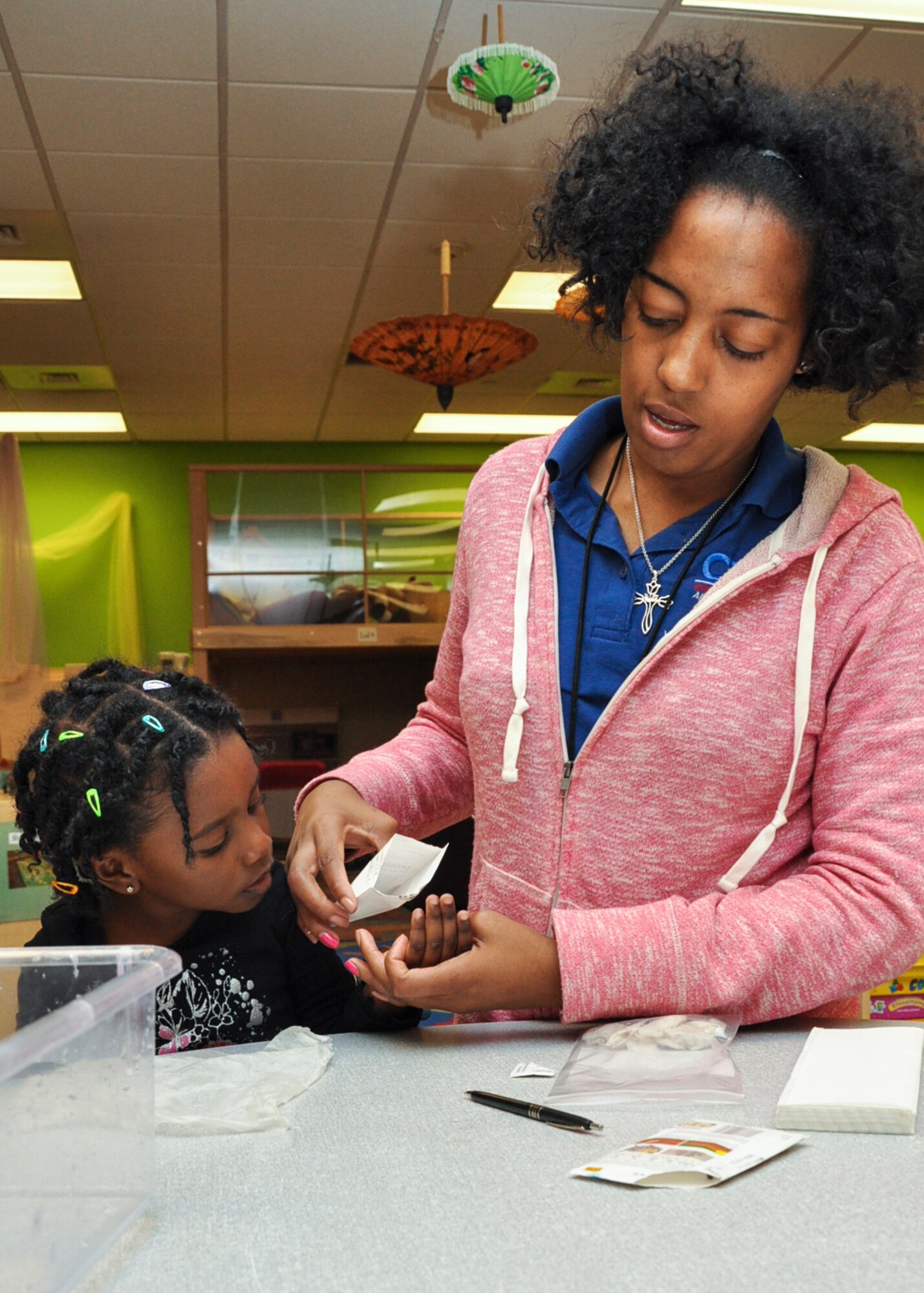 Maryon Bradshaw, A-Basin Child Development Center preschool teacher, pours seeds into Jaelyn Wilson’s hand during a seed germination project April 22, 2013 on Buckley Air Force Base, Colo. The project was done in observance of Earth Day, which was founded by U.S. Senator Gaylord Nelson April 22, 1970. (U.S. Air Force photo by Staff Sgt. Christopher Gross/Released)