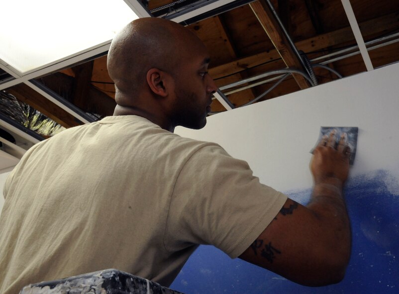 Staff Sgt. Kenneth Jenkins, 2nd Civil Engineer Squadron Structures shop, sands a wall to create a smooth finish on Barksdale Air Force Base, La. April 22, 2013. The structures shop's responsibilities include roof repairs, replacing doors and glass, metal working, masonry and carpentry. (U.S. Air Force photo/Airman 1st Class Andrew Moua)