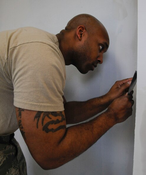Staff Sgt. Kenneth Jenkins, 2nd Civil Engineer Squadron Structures Shop, smooths a wall on Barksdale Air Force Base, La., April 22, 2013. The structures shop's responsibilities include roof repairs, replacing doors and glass, metal working, masonry and carpentry. (U.S. Air Force photo/Airman 1st Class Andrew Moua)