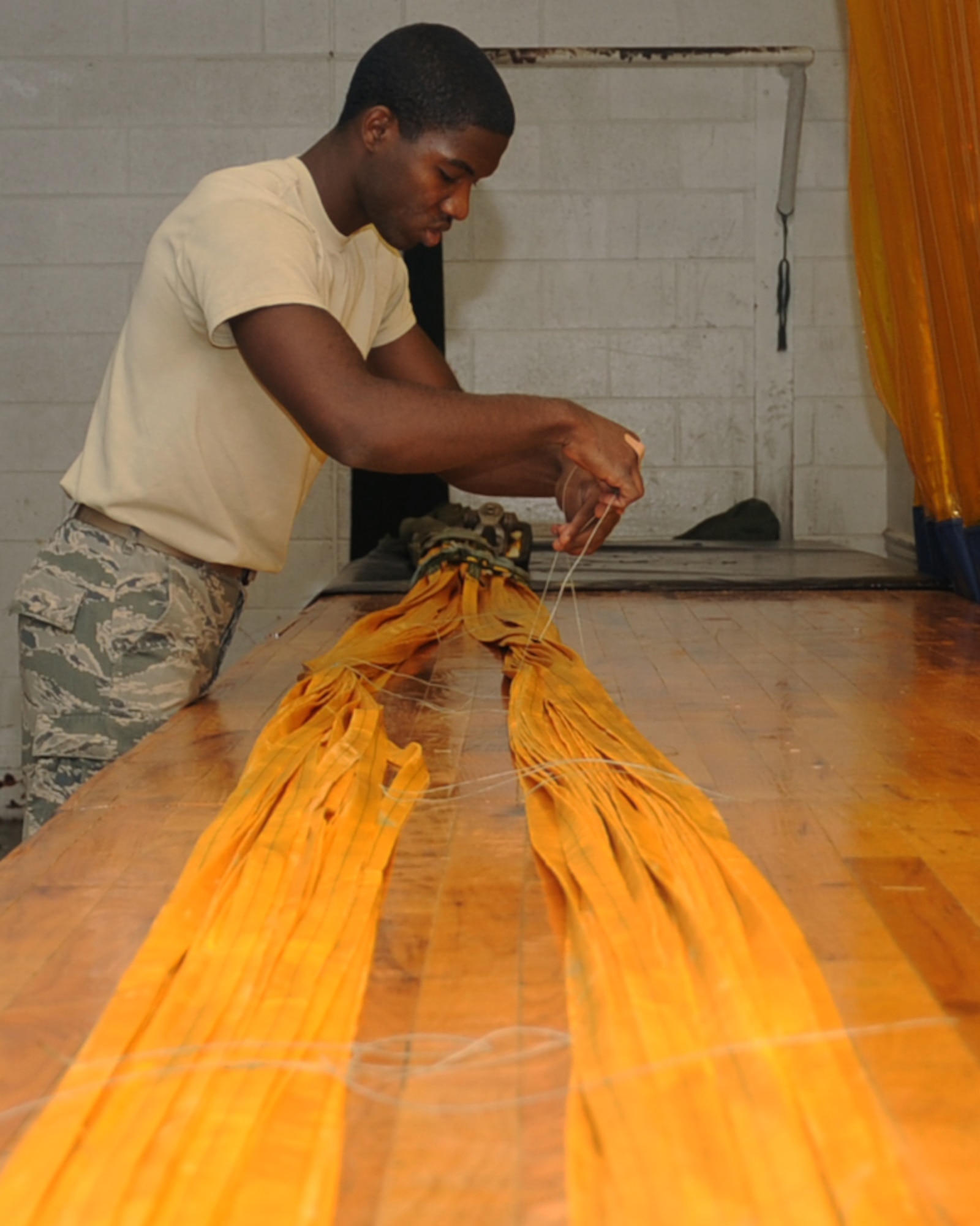 Airman 1st Class Benjamin Green, 2nd Operations Support Squadron Aircrew Flight Equipment, ties lines together on a drag parachute on Barksdale Air Force Base, La., April 22, 2013. Parts of the drag chute are tied together to ensure it does not tangle up during packing or when it is released from the aircraft. The chute is used to slow down a B-52H Stratofortress upon landing. (U.S. Air Force photo/Senior Airman Sean Martin)