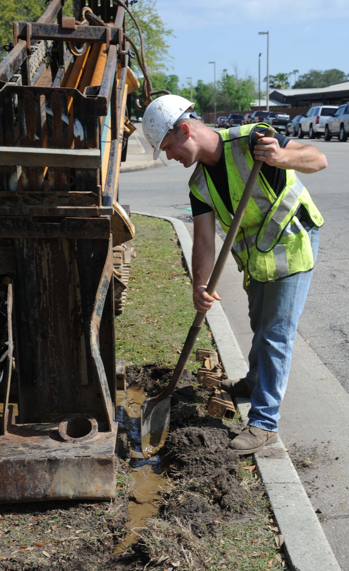 Cody Garrett, Green-Simmons Company contractor, digs a trench for water drainage as he assists in boring a hole for gas line installation April 22, 2013, on the corner of X Street and L Street at Keesler Air Force Base, Miss.  The 11-month project to upgrade the natural gas distribution system at Keesler will touch every corner of the installation and end mid-December.  (U.S. Air Force photo by Kemberly Groue)