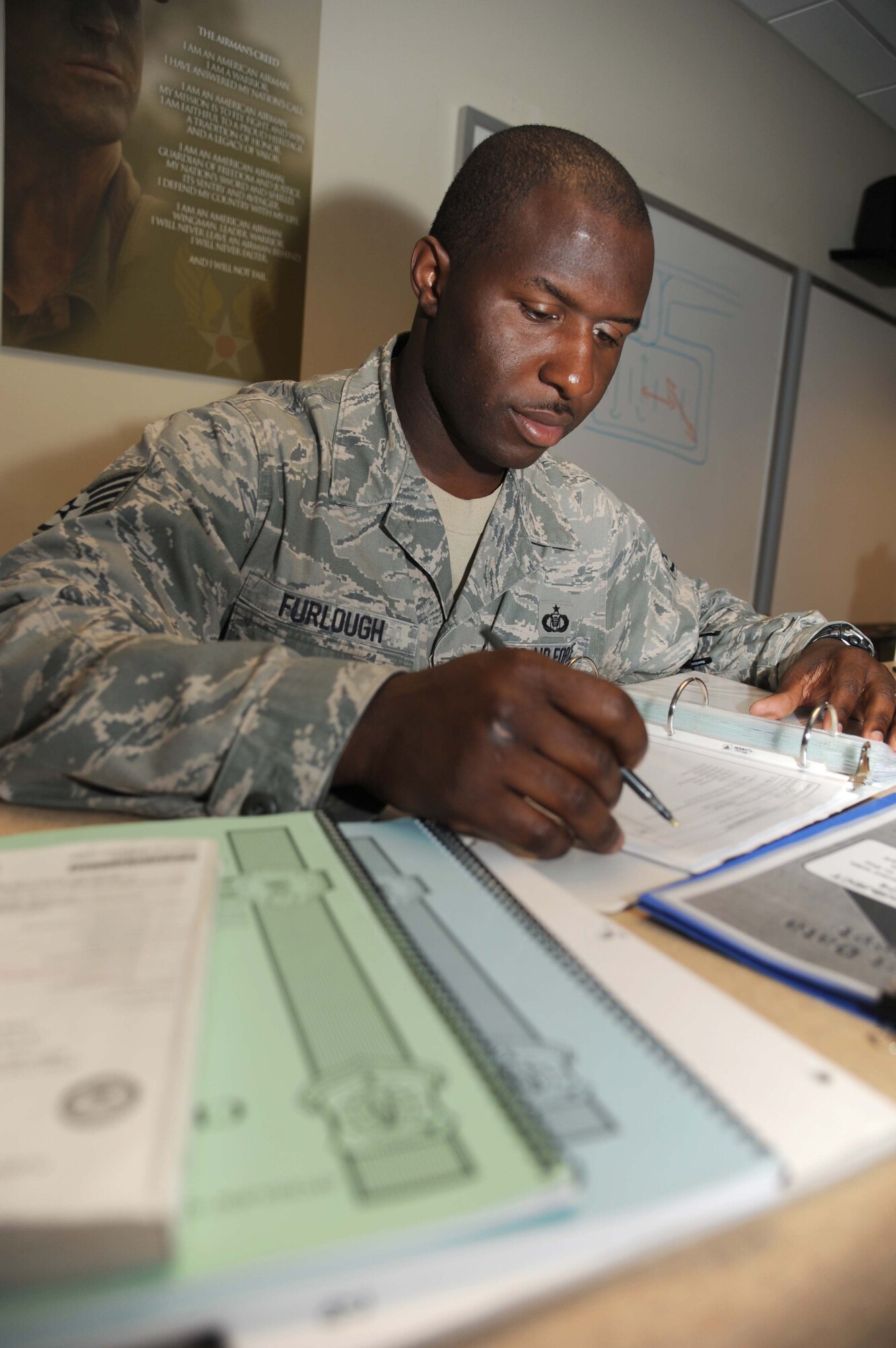 Staff Sgt. Larry Furlough III, 334th Training Squadron airfield management instructor, reviews study guides for his students during class April 19, 2013, at Cody Hall, Keesler Air Force Base, Miss.  Across the Air Force, about 10 people share the same unusual surname, including his brother, Tech. Sgt. Anthony Furlough, and his sister-in-law, Capt. Jasmin Furlough, both assigned to the 59th Medical Wing, Joint Base San Antonio-Lackland, Texas.  (U.S. Air Force photo by Kemberly Groue)