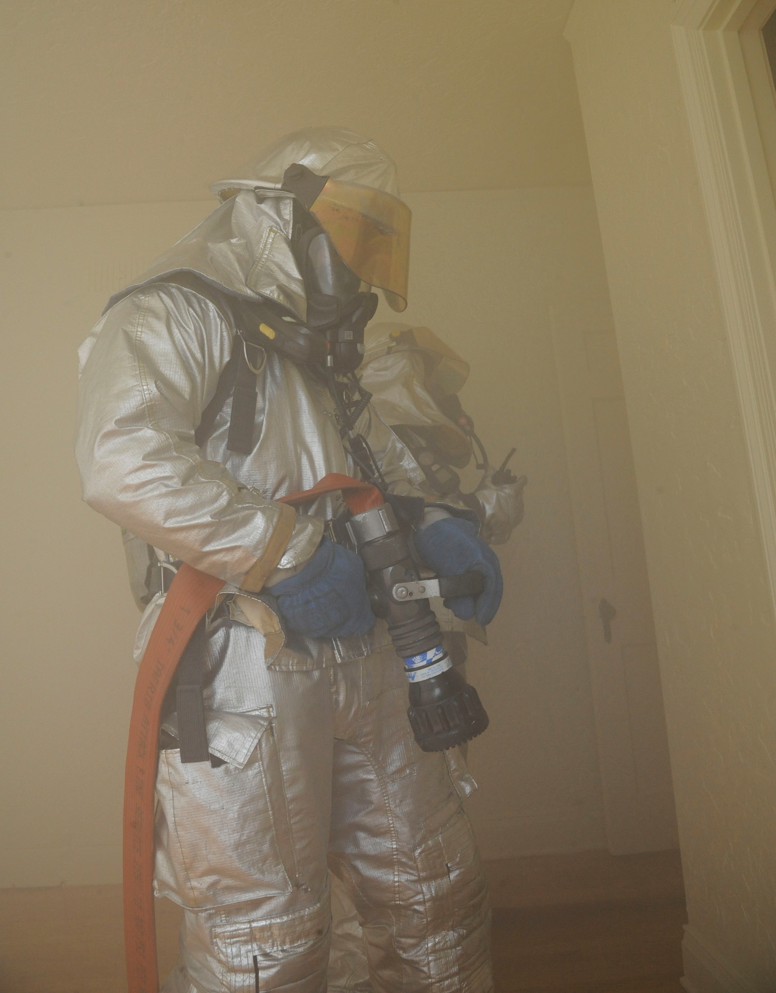 Kelly Cravens, foreground, and Senior Airman Trey Moorer, 2nd Civil Engineer Squadron firefighters, simulate extinguishing a fire during an exercise on Barksdale Air Force Base, La., April 20, 2013. The exercise put firefighters in a simulated house fire where they established water lines, practiced methods of entry and extinguished simulated fires. (U.S. Air Force photo/Airman 1st Class Andrew Moua)