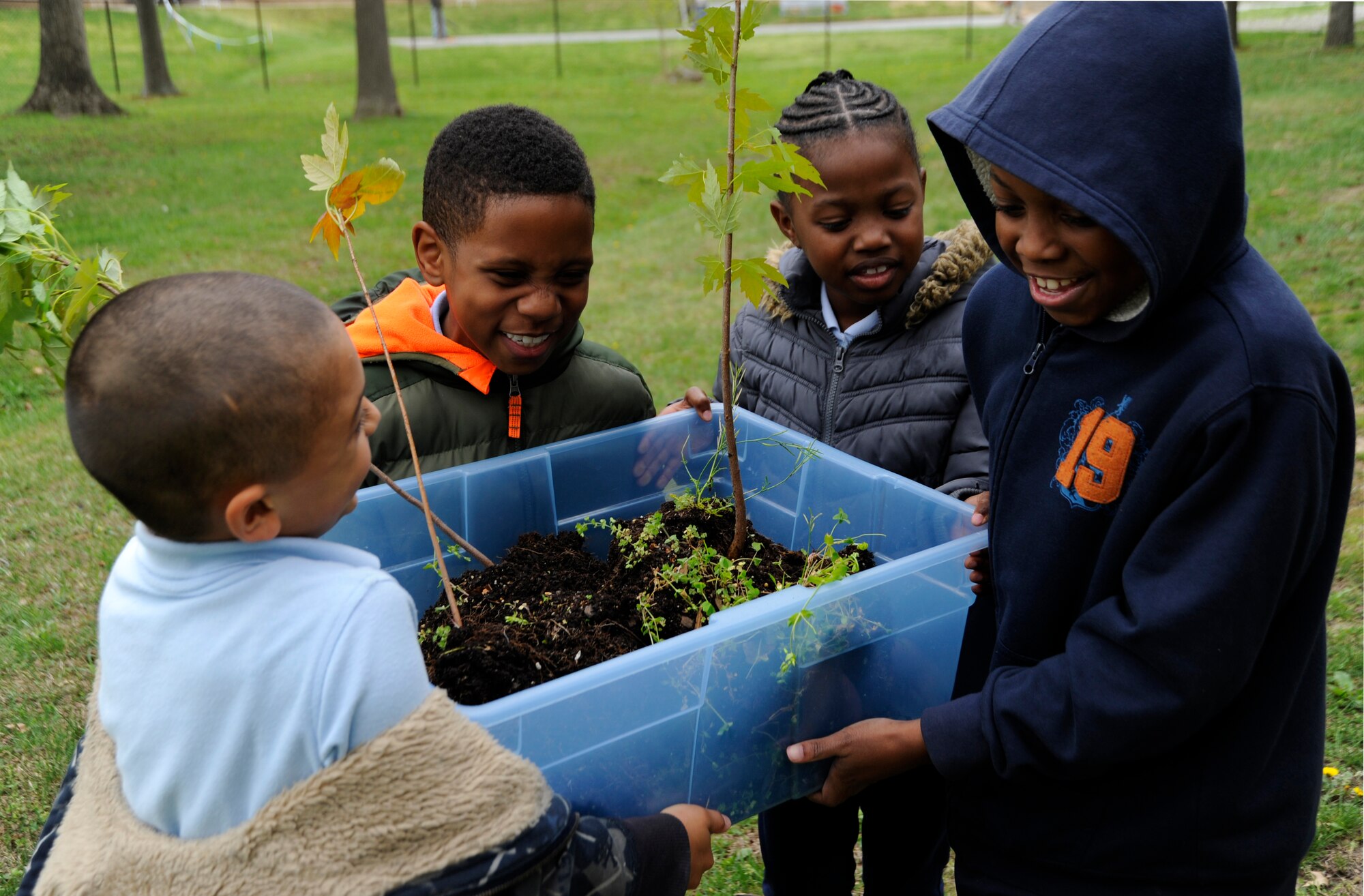Joint Base Andrews Youth Center children carry small trees to be planted in the behind the Youth Center woods in celebration of Earth Day on Joint Base Andrews, Md., April 22, 2013. In one year, an acre of trees can absorb as much carbon as is produced by a car driven up to 8,700 miles according to the International Society of Arboriculture. (U.S. Air Force photo/Airman 1st Class Nesha Humes)
