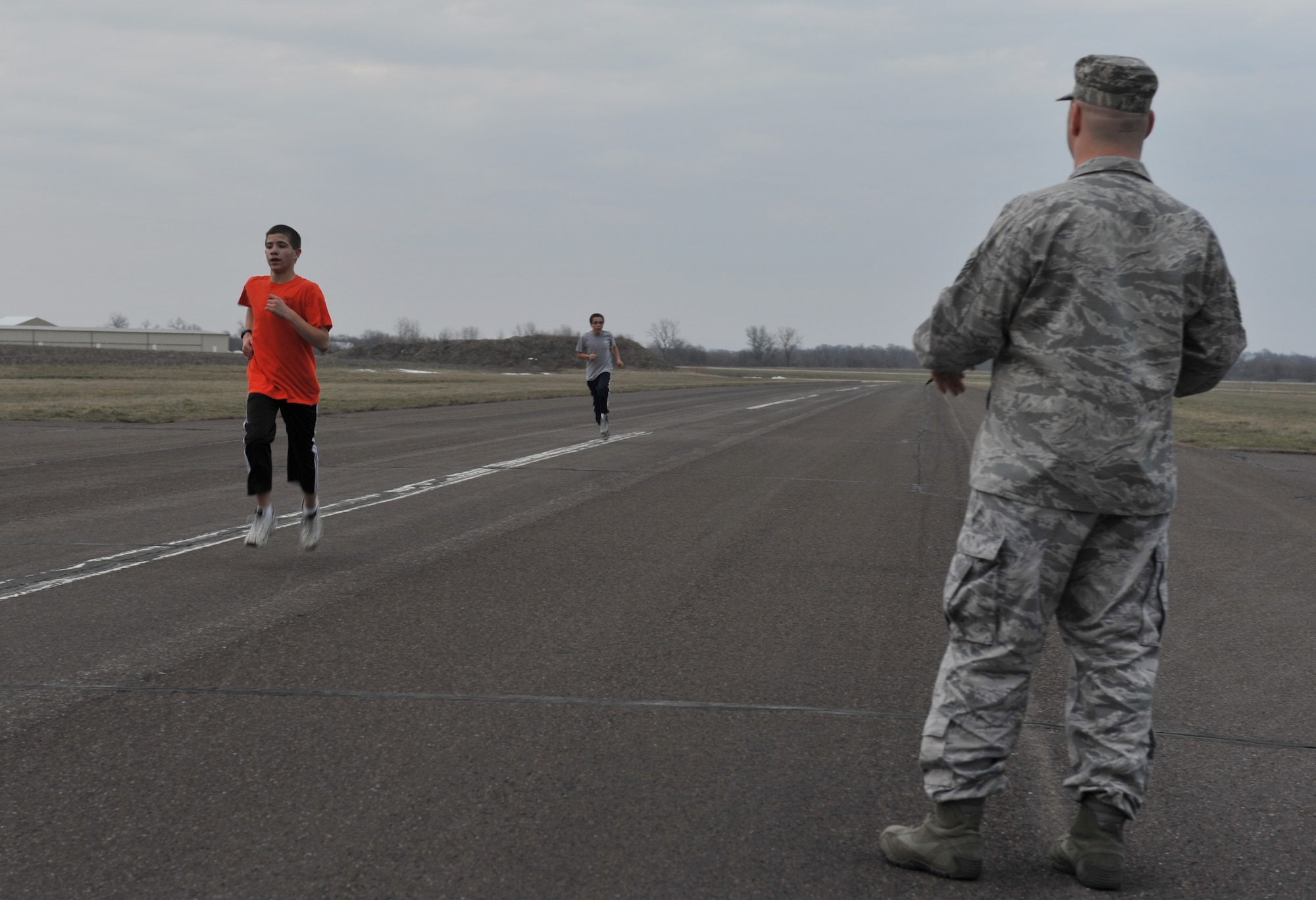Master Sgt. William Sander, 509th Comptroller Squadron financial services superintendent, records run times for  Alex, 14, and Breandan, 13, Civil Air Patrol cadets during their physical fitness assessment, March 28, 2013, in Sedalia, Mo.. Sander also monitors for safety during all cadet activities. (U.S. Air Force photo by Heidi Hunt/Released)
