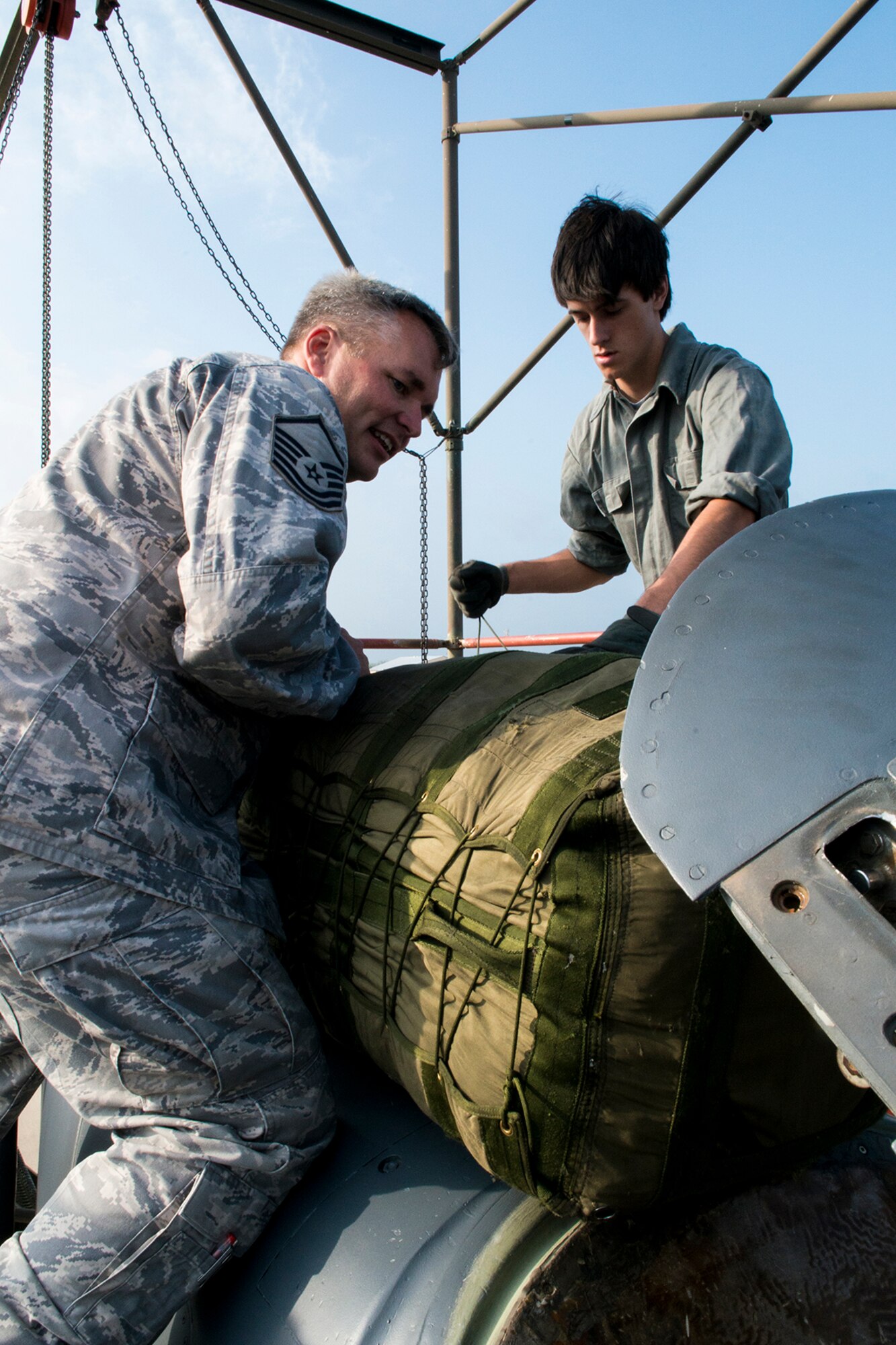 Daniel Phillips (right) helps U.S. Air Force Master Sgt. Preston Bryan install a drag parachute into the tail section of a B-52H Stratofortress, April 17, 2013, Barksdale Air Force Base, La. Phillips is studying the effects of drag on an aircraft for a senior project at Haughton High School, Haughton, La. (U.S. Air Force photo by Master Sgt. Greg Steele/Released)