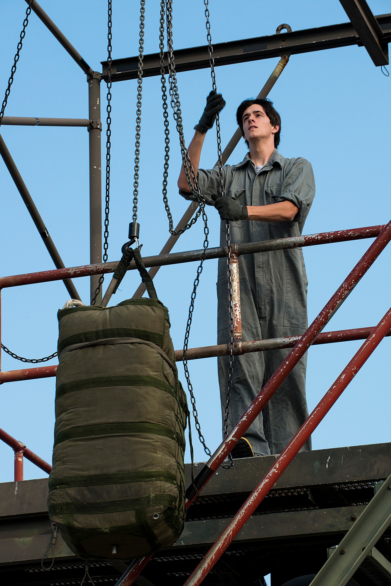 Daniel Phillips, a Haughton High School senior, hoists up a drag parachute which will be loaded into the tail section of a B-52H Stratofortress, April 17, 2013, Barksdale Air Force Base, La. For a senior project, Phillips is studying the effects of drag on an aircraft and was given the opportunity to help 307th Aircraft Maintenance Squadron crew chiefs install a parachute. (U.S. Air Force photo by Master Sgt. Greg Steele/Released)