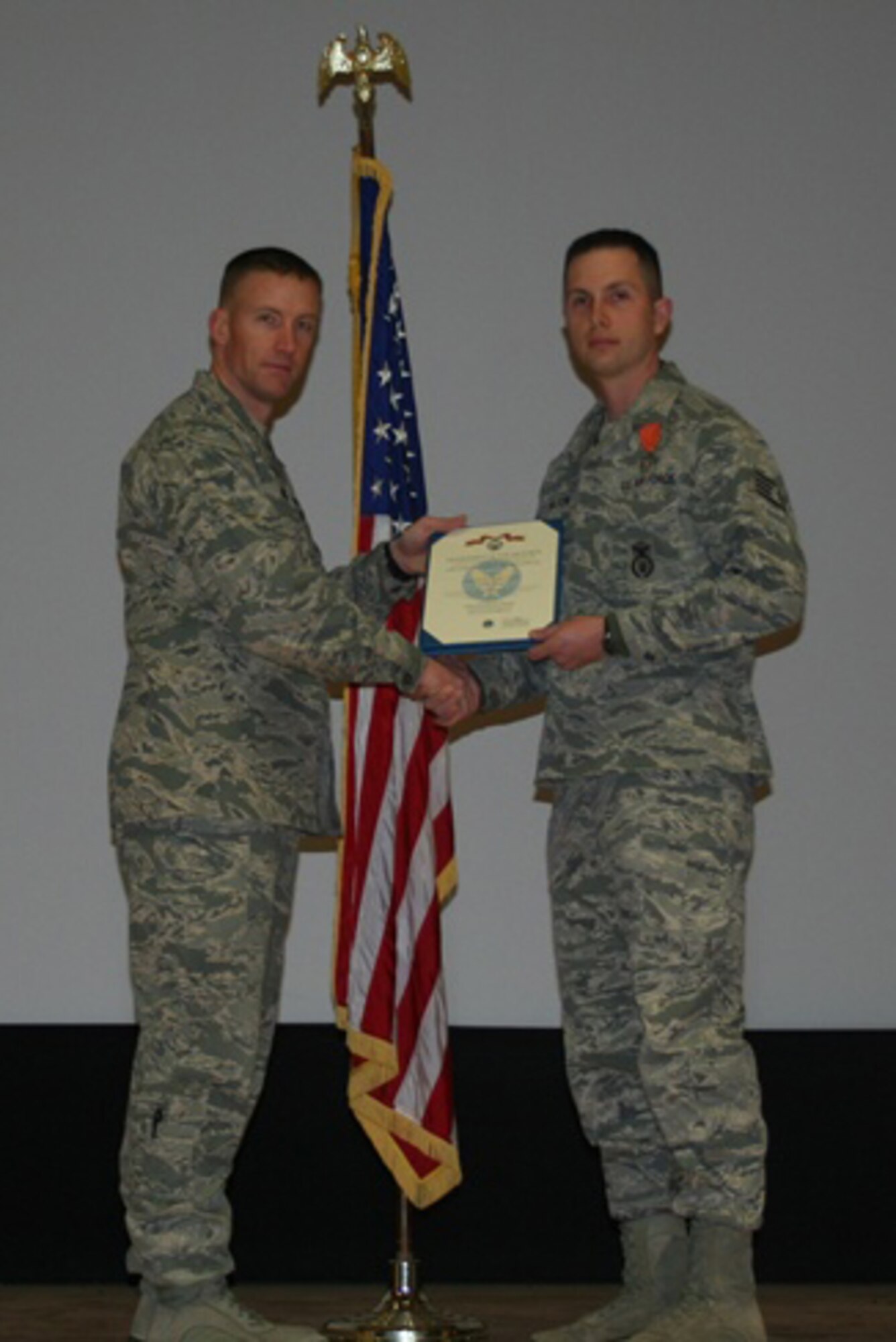 U.S. Air Force Maj. Ryan Bodge, 366th Security Forces Squadron commander awards Staff Sgt. Robert Wilson, 366th SFS military working dog handler, the Air Force Combat Action Medal Feb. 25, 2013, at Mountain Home Air Force Base, Idaho. Wilson received the medal for his actions while deployed in support of Operation Enduring Freedom. (Courtesy photo)