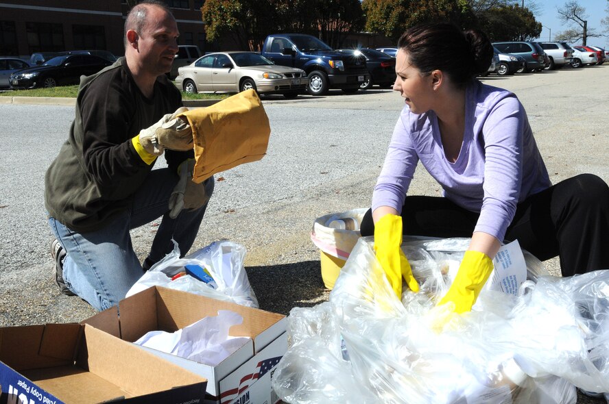 U.S Air Force Major Oscar Ahumada, 459th Force Support Squadron, and Senior Airman Melissa Klingler, privacy act manager for the 459th Air Refueling Wing at Joint Base Andrews Md., go through trash bags looking for improper disposable of privacy act information, April 14, 2013. The dumpster-diving is an effort to make member information not so readily available. (U.S. Air Force photo/ Tech. Sgt. Steve Lewis)