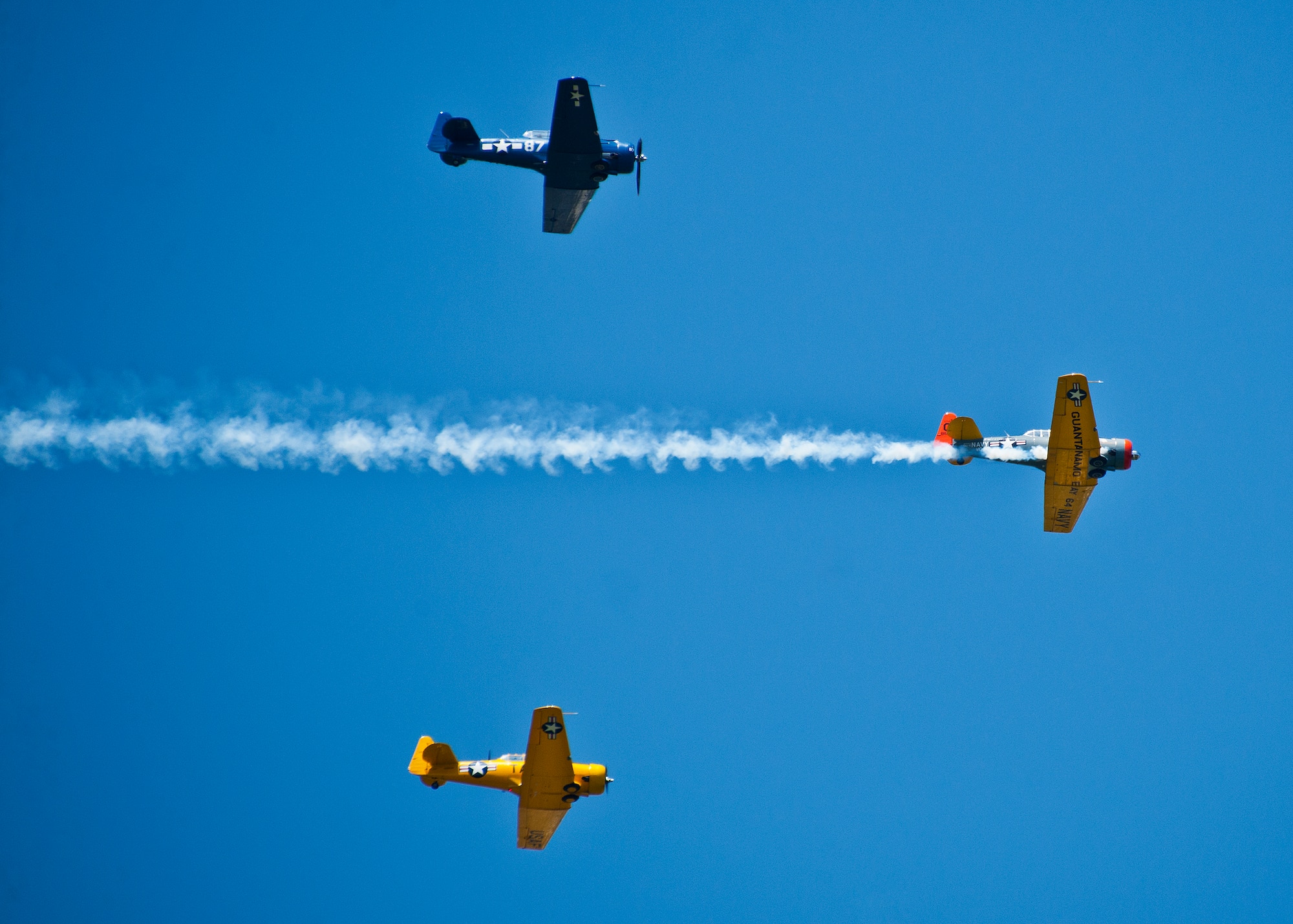 T-6 aircraft fly in formation celebrating the Parade of Heroes and the Doolittle Raiders April 20.  The T-6s were part of a parade of vintage World War II era aircraft, including the B-25, which performed flyovers during the event.  (U.S. Air Force photo/Samuel King Jr.)