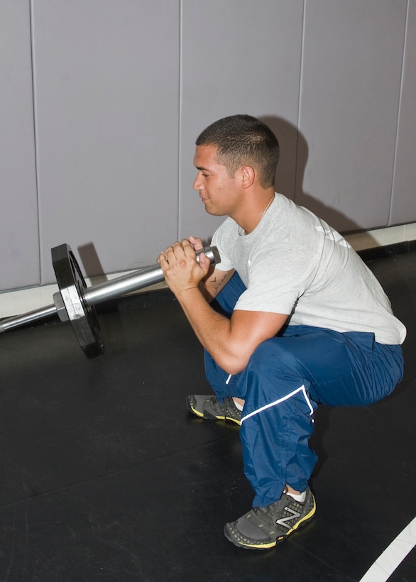 Airman 1st Class Joseph Kay, 7th Force Support Squadron, performs the second step in the barbell jammer exercise, April 17, 2013, at Dyess Air Force Base, Texas. (U.S. Air Force photo by Airman 1st Class Peter Thompson/Released)