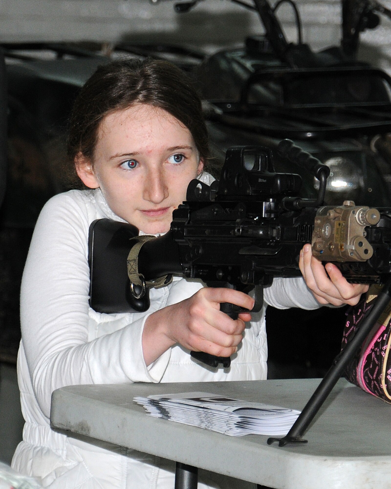 Megan Ireland, 15, daughter of Col. Christopher Ireland, 352nd Special Operations Group commander, holds a Mark-46 light machine gun April 19, 2013, at RAF Mildenhall, England. Job Shadow Day was an academically-motivating activity designed to give students the unique opportunity to take an up-close look at various careers within the Air Force. (U.S. Air Force photo by Gina Randall/Released)