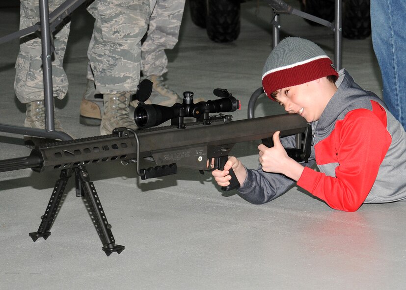 Ryan Freeman, 11, son of Lt. Col. William Freeman, 7th Special Operations Squadron commander, looks down the barrel to hold a Barrett M-107 .50 caliber sniper rifle April 19, 2013, at RAF Mildenhall, England. As part of Job Shadow Day, children received an overview of the 321st Special Tactics Squadron career field with combat controllers and pararescuemen. (U.S. Air Force photo by Gina Randall/Released)