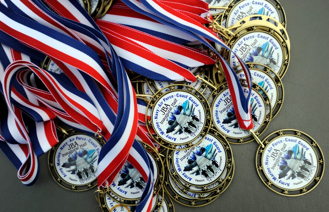 Participants of the Inaugural Joint Base Andrews Half Marathon are awarded with medals as they cross the finish line April 20, 2013. The first place runner was Brenda Shrank who finished with a time of one hour, 24 minutes and nine seconds. (U.S. Air Force photo/Staff Sgt. Brittany E. Jones)