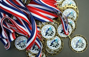 Participants of the Inaugural Joint Base Andrews Half Marathon are awarded with medals as they cross the finish line April 20, 2013. The first place runner was Brenda Shrank who finished with a time of one hour, 24 minutes and nine seconds. (U.S. Air Force photo/Staff Sgt. Brittany E. Jones)