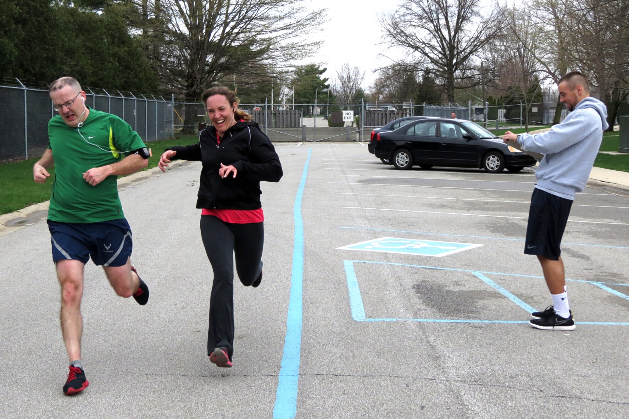 GRISSOM AIR RESERVE BASE, Ind. -- Chris Witter overtakes Brandie Vandokkenburg at the finish of a predict-a-time 5k run held at the Grissom Fitness Center April 16, while Chris Wiley, 434th Force Support Squadron lead physical fitness technician calls out their times. Debra Wilson-Strong was the first-place winner in the event finishing four seconds off her predicted time. (U.S. Air Force photo/Becca Hammer)