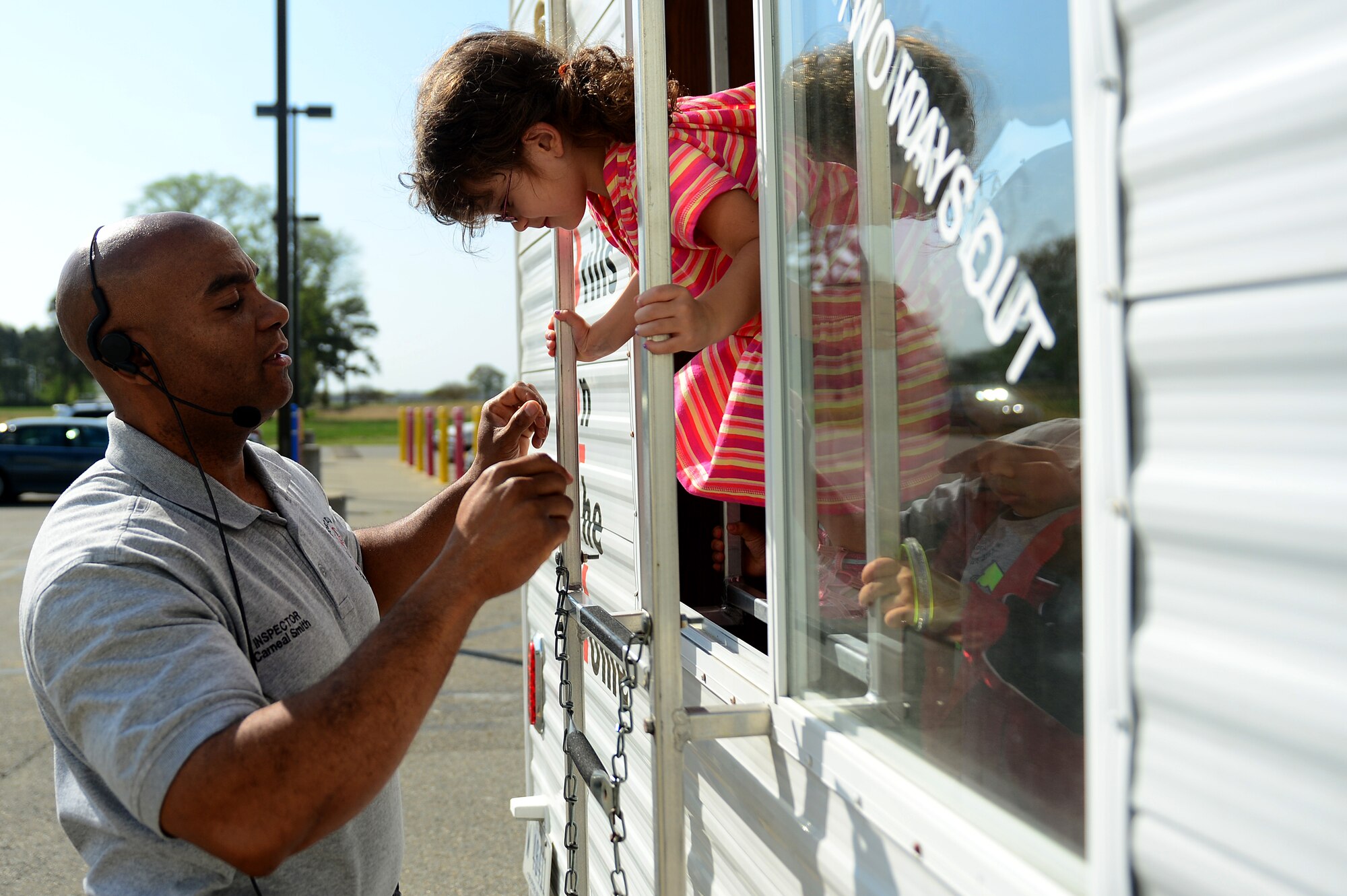 Carneal Smith, 733rd Civil Engineer Division Fire and Emergency Services inspector, helps a young child practice evacuating a home during a training exercise on fire safety and prevention at Langley Air Force Base, Va., April 17, 2013. Children learned about fire safety by watching an interactive video and participating in hands-on exercises. (U.S. Air Force photo by Senior Airman Kayla Newman/Released)