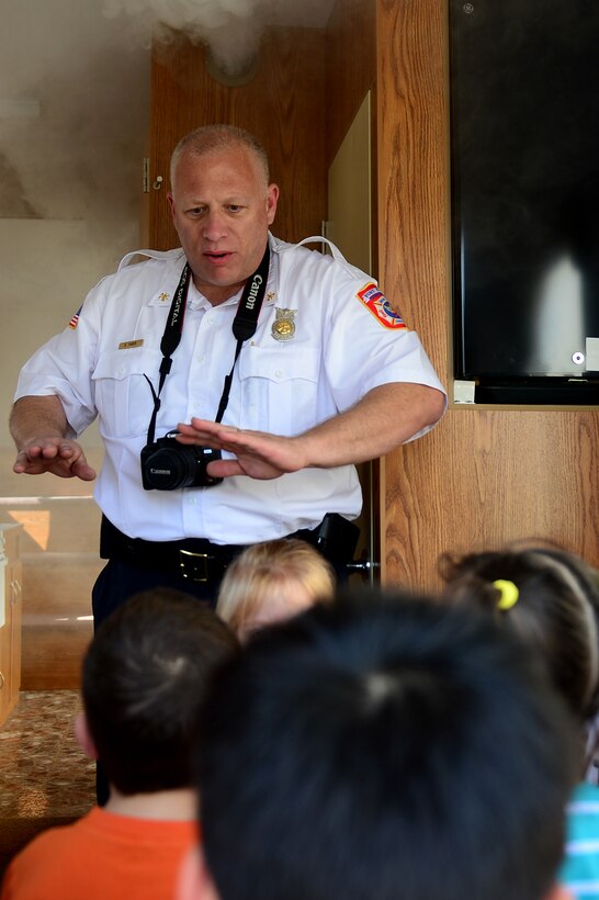 Douglas Faber, 733rd Civil Engineer Division Fire and Emergency Services assistant chief of fire prevention and public education, teaches a hands-on education training class at Langley Air Force Base, Va., April 17, 2013 to explain to children what to do when they see smoke in a home. The Fort Eustis, Va., fire department traveled to the NASA Child Development Center to teach kids about the importance of fire safety and prevention. (U.S. Air Force photo by Senior Airman Kayla Newman/Released)