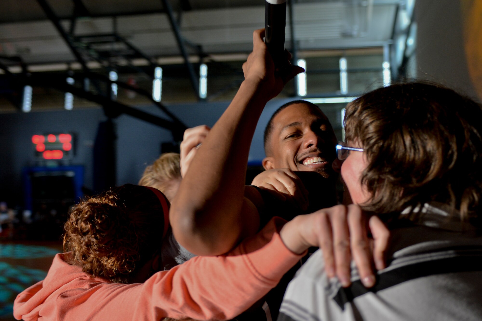 Nick Cannon is embraced by fans during his halftime performance on Ramstein Air Base, Germany, April 19, 2013. Cannon was a part of the United Service Organization’s team of actors, musicians and comedians who played in a friendly basketball game to show support to the troops. (U.S. Air Force photo/Airman 1st Class Jordan Castelan)