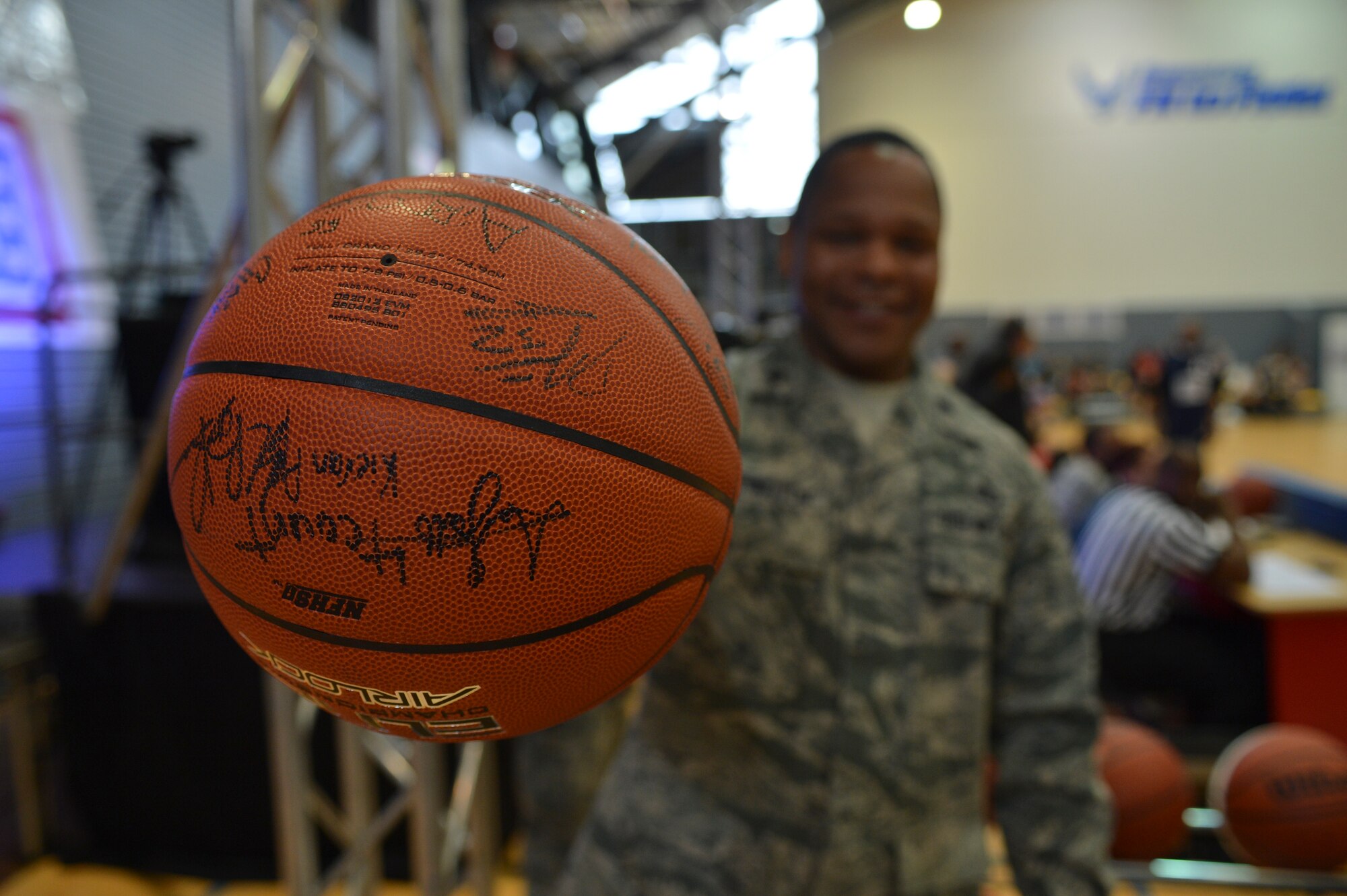 Lt. Col. Keithen Washington, 86th Force Support Squadron commander, holds the signed game ball prior to tip off on Ramstein Air Base, Germany, April 19, 2013. Ramstein’s varsity basketball team participated in a friendly basketball match against Power 106 and Nick Cannon N’ Credible United Service Organization tour in a morale event to show support to the troops. (U.S. Air Force photo/Airman 1st Class Jordan Castelan)