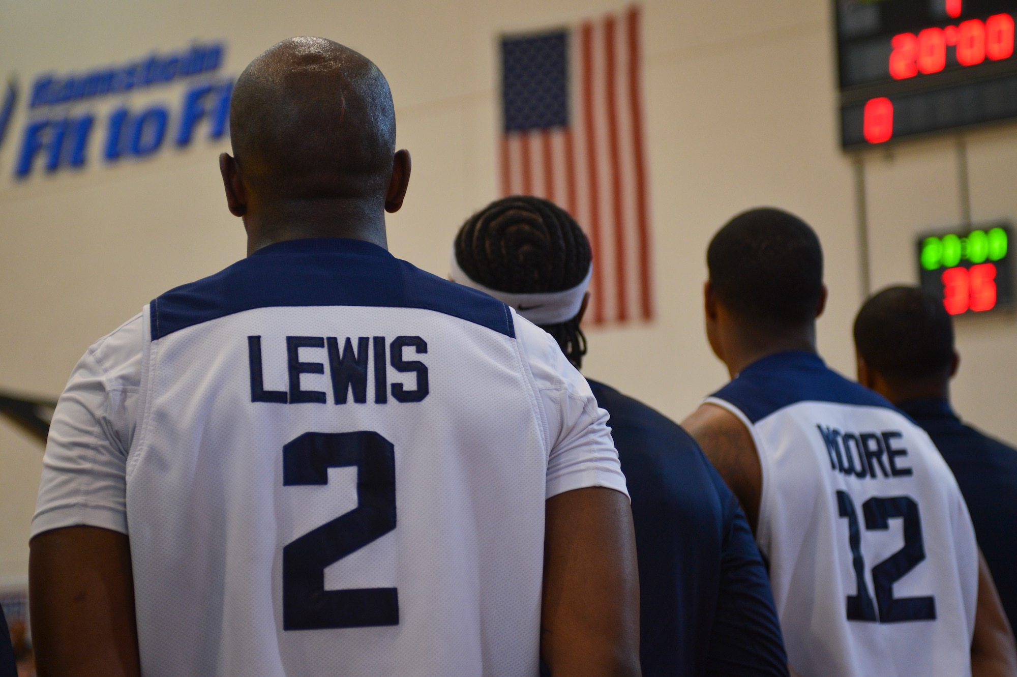 Members of Ramstein’s varsity basketball team observe the flag during the singing of the National Anthem on Ramstein Air Base, Germany, April 19, 2013. The basketball team participated in a friendly match against Power 106 and Nick Cannon N 'Credible United Service Organization tour in a morale event to show support to the troops. (U.S. Air Force photo/Airman 1st Class Jordan Castelan)