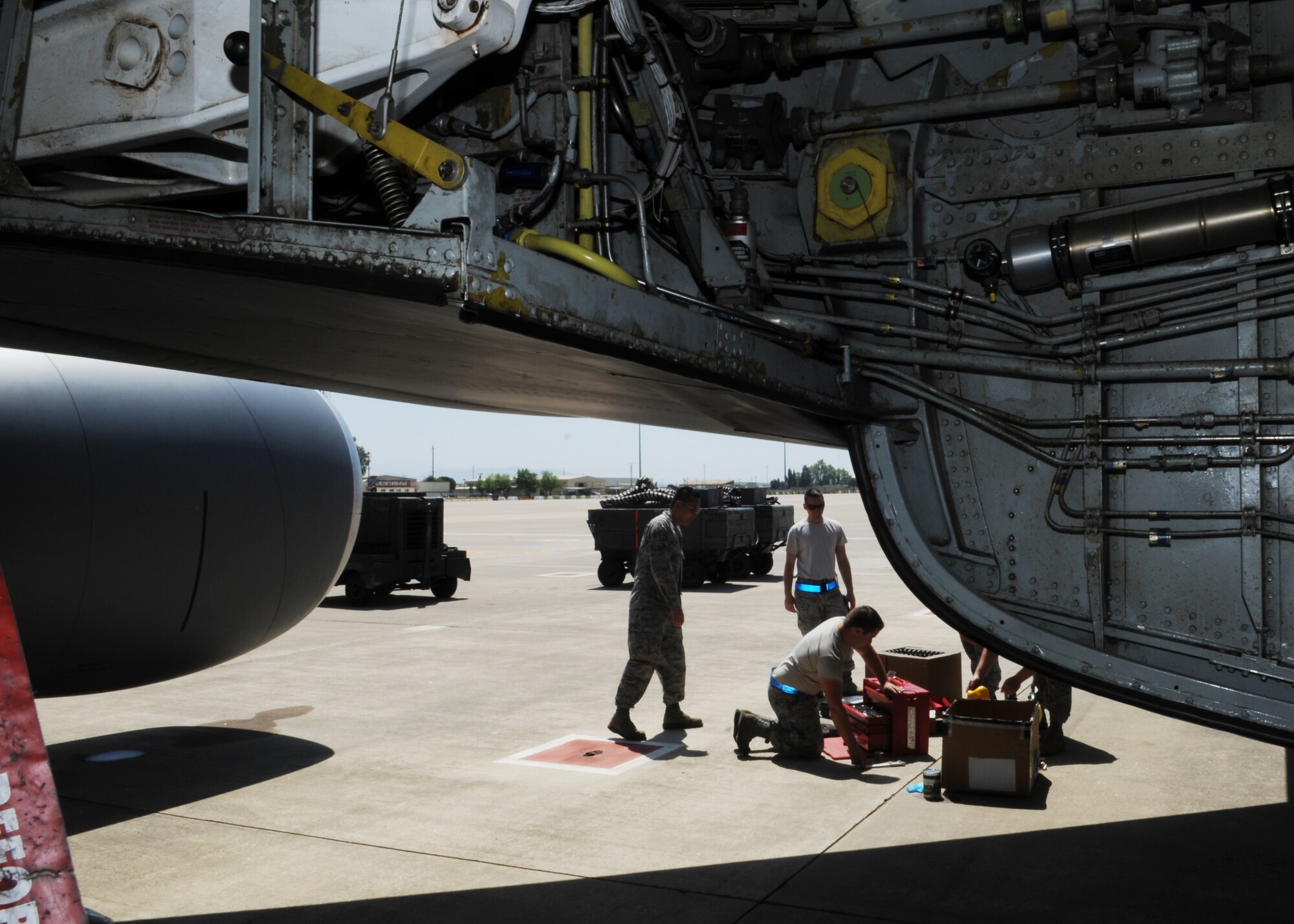 Airmen with the 100th Maintenance Squadron collect their tools and old parts prior to testing the bleed air on a KC-135 Stratotanker while deployed with the 351st Expeditionary Air Refueling Squadron April 18, 2013, in Southwest Europe. The bleed air is used to help control the climate on the aircraft during flight. (U.S. Air Force photo by 1st Lt. Christopher Mesnard/Released)
