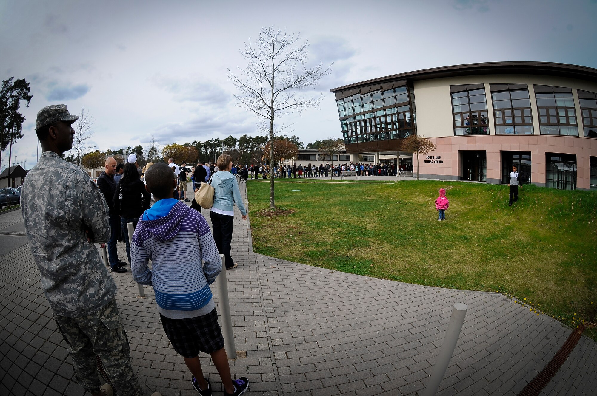 A crowd gathers outside the Southside Fitness Center to see members of Power 106 and Nick Cannon N 'Credible United Service Organization tour participate in a friendly exhibition match against Ramstein's varsity basketball team on Ramstein Air Base, Germany, April 19,2013. USO's lineup included actors, musicians and comedians competing against Ramstein's finest basketball players in a morale event to show support to the troops. (U.S. Air Force photo/Airman 1st Class Jordan Castelan)