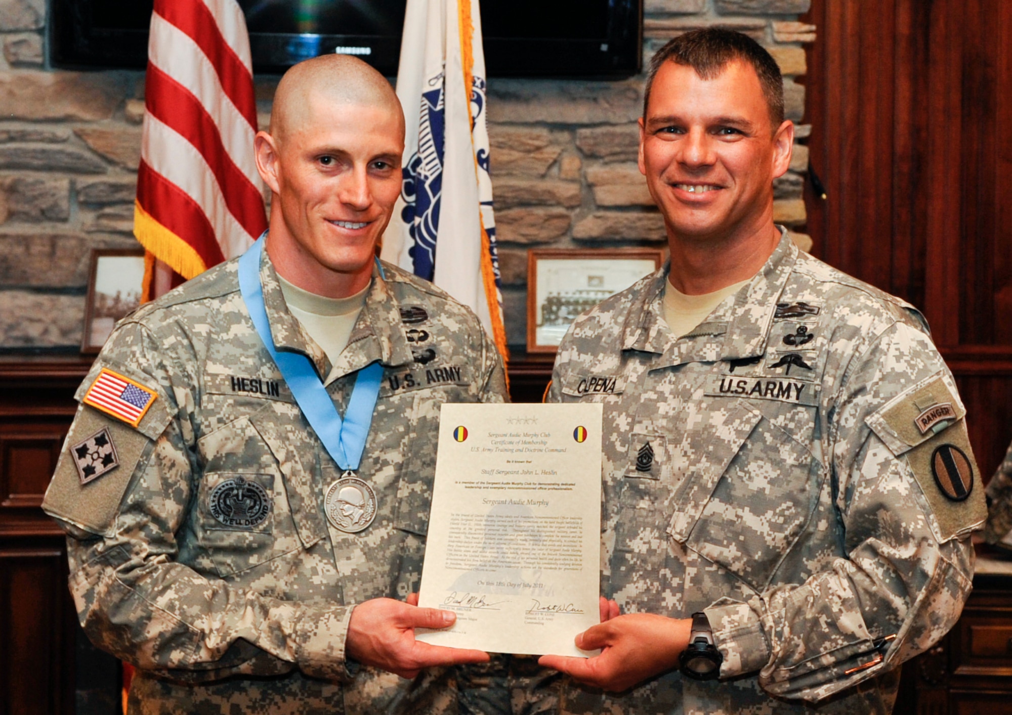 (From left) U.S. Army Sgt. 1st Class John Heslin, U.S. Army Training and Doctrine Command 2011 Drill Sergeant of the Year winner, is inducted into the Audie Murphy Association by Sgt. Maj. John Calpena, Initial Military Training command sergeant major, during an induction ceremony at Fort Eustis, Va., April 18, 2013. The association is limited to noncommissioned officers, and inductees are considered among the best in their field. On average, only 2 percent of NCOs receive the award. (U.S. Air Force photo by Staff Sgt. Wesley Farnsworth/Released)