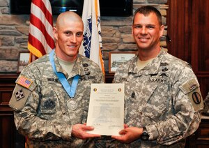 (From left) U.S. Army Sgt. 1st Class John Heslin, U.S. Army Training and Doctrine Command 2011 Drill Sergeant of the Year winner, is inducted into the Audie Murphy Association by Sgt. Maj. John Calpena, Initial Military Training command sergeant major, during an induction ceremony at Fort Eustis, Va., April 18, 2013. The association is limited to noncommissioned officers, and inductees are considered among the best in their field. On average, only 2 percent of NCOs receive the award. (U.S. Air Force photo by Staff Sgt. Wesley Farnsworth/Released)