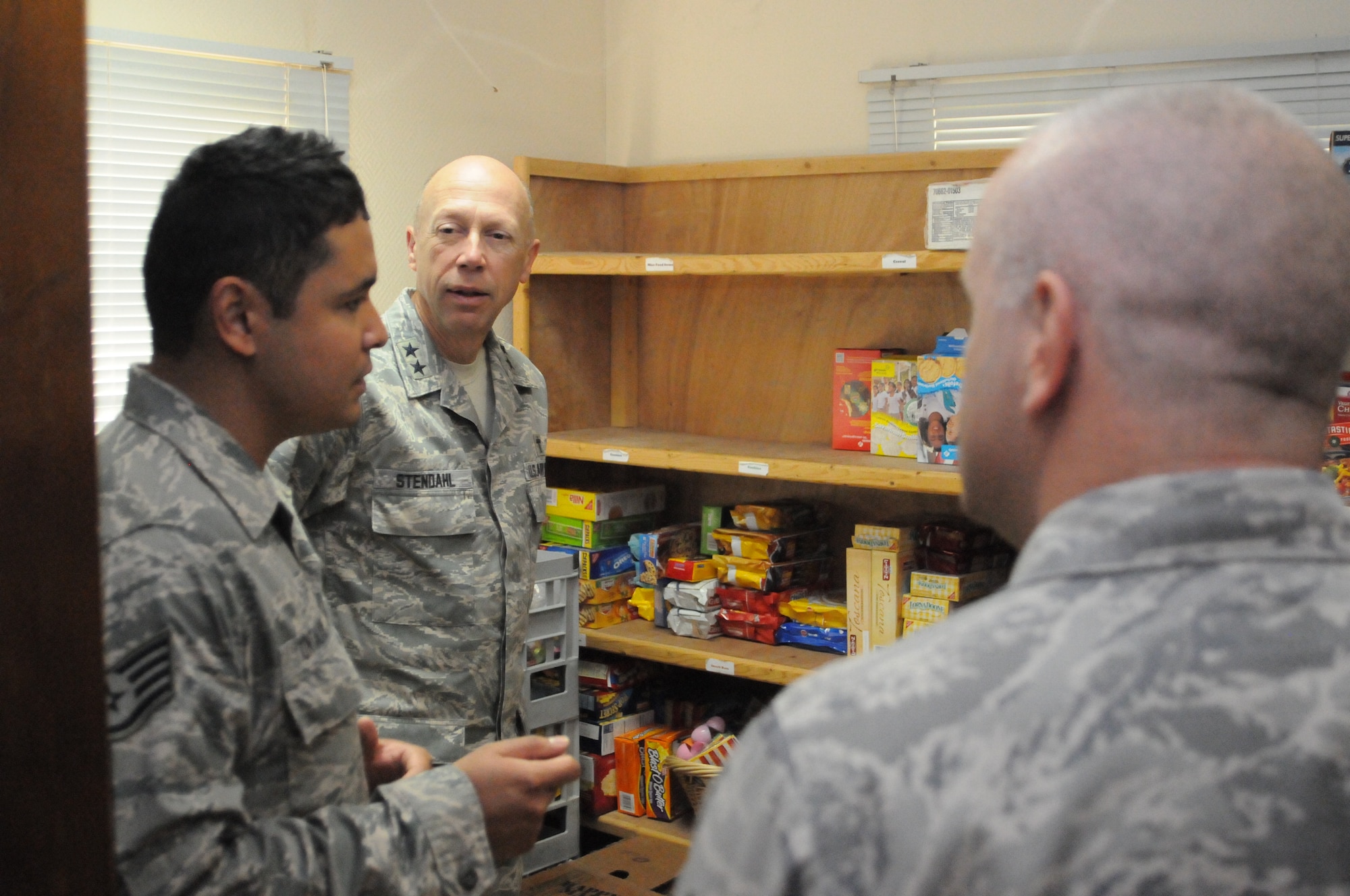 SOUTHWEST ASIA -- Air Force Chief of Chaplains Major General Howard Stendahl, center, and Chaplain Assistant Career Field Manager Chief Master Sgt. Alton Clemmons, right, listen as chaplain assistant Staff Sgt. Bernard Untalan shows them food storage at Jack's Place, a chapel-run spot for deployed service members in Southwest Asia. Stendahl and Clemmons visited the 379th Air Expeditionary Wing April 14-15, speaking with Airmen and touring chaplain programs supporting operations here. Stendahl thanked various volunteer and religious groups for their support of Airmen deployed to Southwest Asia. (U.S. Air Force photo/Master Sgt. Christian Michael)
