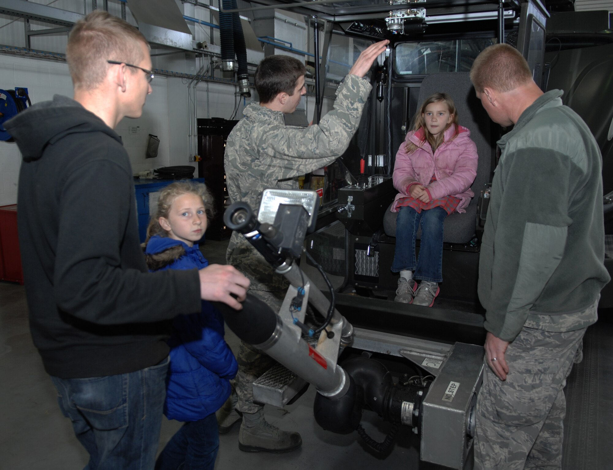 Team Mildenhall members explain how 100th Logistics Readiness Squadron heavy machinery works to Job Shadow Day participants April 19, 2013, on RAF Mildenhall, England. Job Shadow Day is an academically-motivating activity designed to give students the unique opportunity to take an up-close look at various Air Force careers such as firefighters, security forces and air traffic controllers. (U.S. Air Force photo by Airman 1st Class Dillon Johnston/Released)