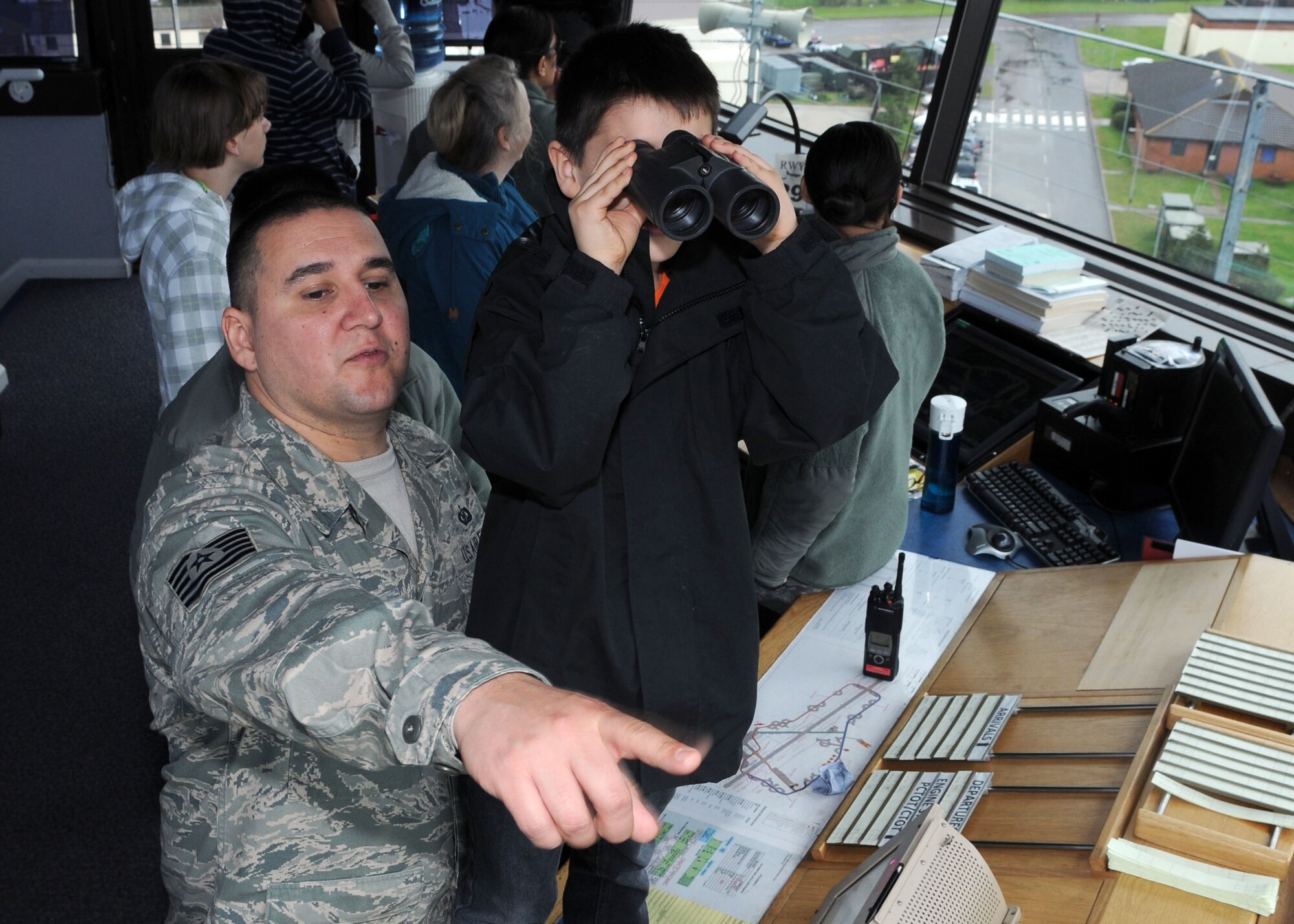 Tech. Sgt. Francisco Moreno, 321st Special Tactic Squadron Air Crew Flight Equipment NCO in charge from Tucson, Ariz., and his son Francisco Moreno II, 8, watch the flightline from the 100th Operations Support Squadron Air Traffic Control Tower during Job Shadow Day April 19, 2013, at RAF Mildenhall, England.  Students and parents toured the nine-story tower, observed controllers managing aircraft flying in and out of RAF Mildenhall and visited the ATC simulator. (U.S. Air Force photo by Staff Sgt. Tabitha M. Lee/Released)