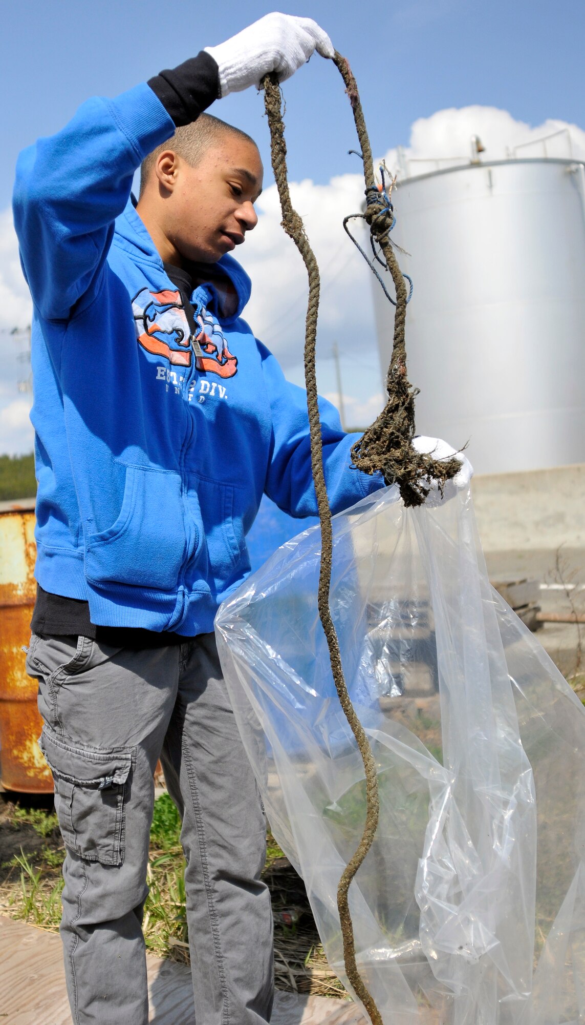 U.S. Air Force Tech. Sgt. Thomas Troxler’s son, places a discarded rope into a bag at the 15th Annual Misawa Port Cleanup, April 20, 2013. Last year more than 20,000 pounds of garage and recyclables were removed from the port. (U.S. Air Force photo by Tech. Sgt. Phillip Butterfield)