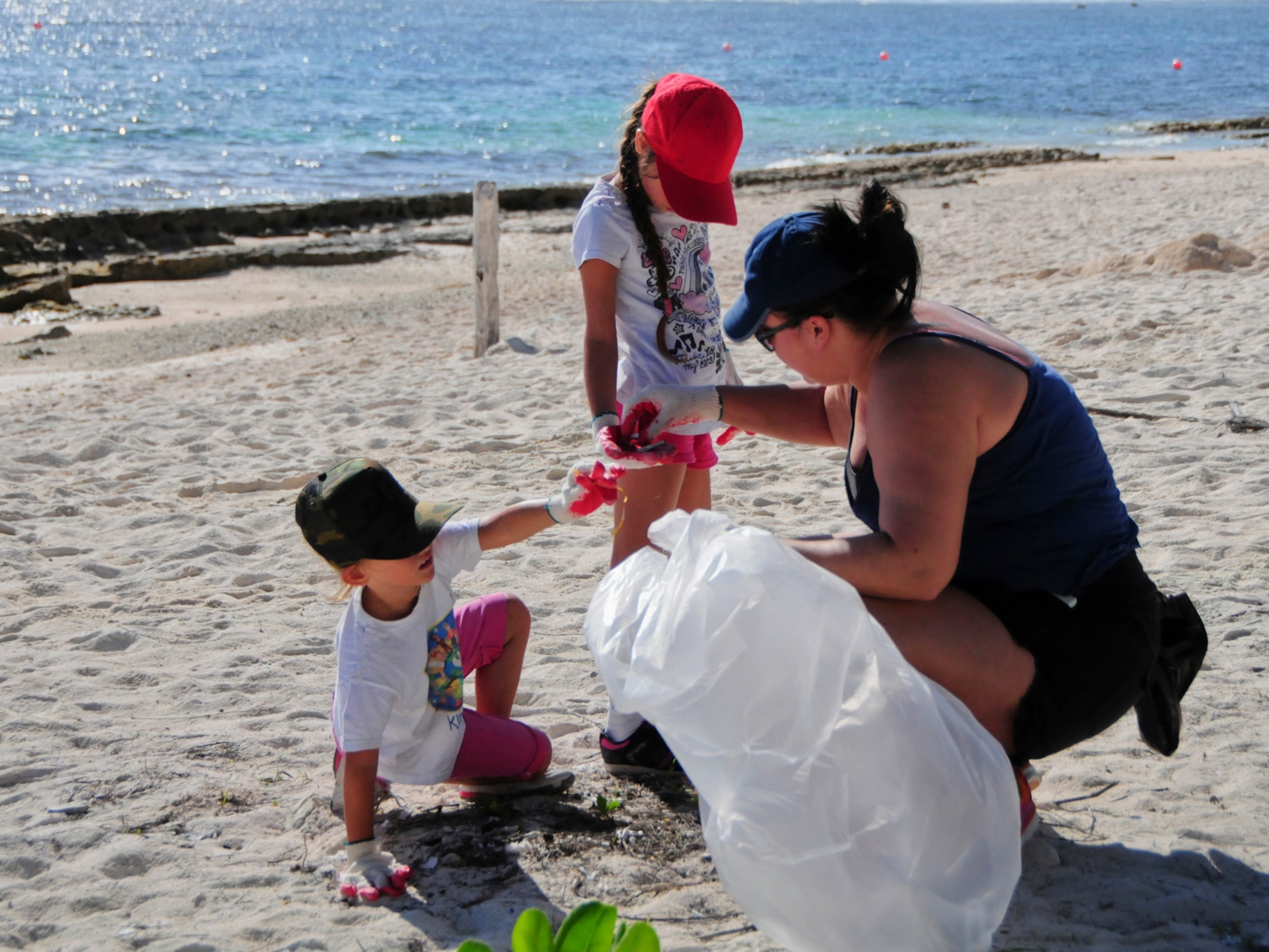 A family works together to collect and sort trash during the Earth Day cleanup on Tarague Beach at Andersen Air Force Base, Guam, April 21, 2013. Along with collecting trash, volunteers tracked the amount and brands of the waste they collected, which was sent to the U.S. Environmental Protection Agency Regions 9 for their study on sources of rubbish in oceans. (U.S. Air Force photo by Airman 1st Class Marianique Santos/Released)