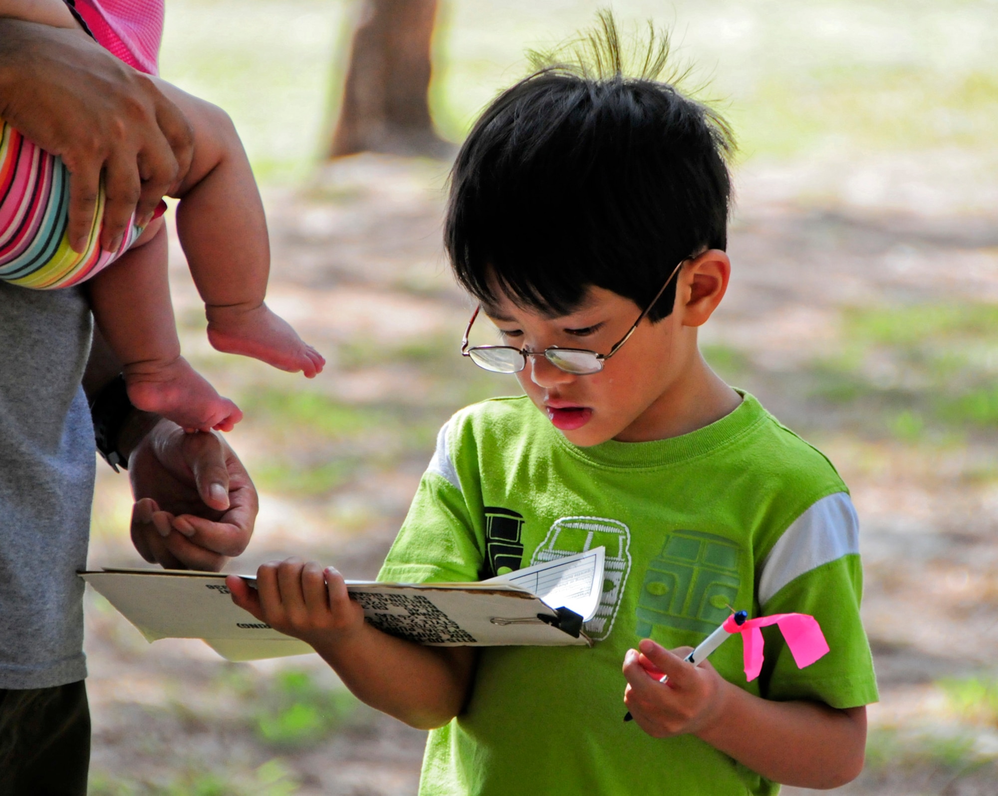 A young volunteer keeps track of the trash that his family collects during the Earth Day cleanup on Tarague Beach at Andersen Air Force Base, Guam, April 21, 2013. In celebration of Earth Day, the 36th Civil Engineer Squadron environmental flight facilitated a beach cleanup, displayed natural, cultural and historical exhibits, offered educational games and gave out prizes to promote environmental awareness. (U.S. Air Force photo by Airman 1st Class Marianique Santos/Released)