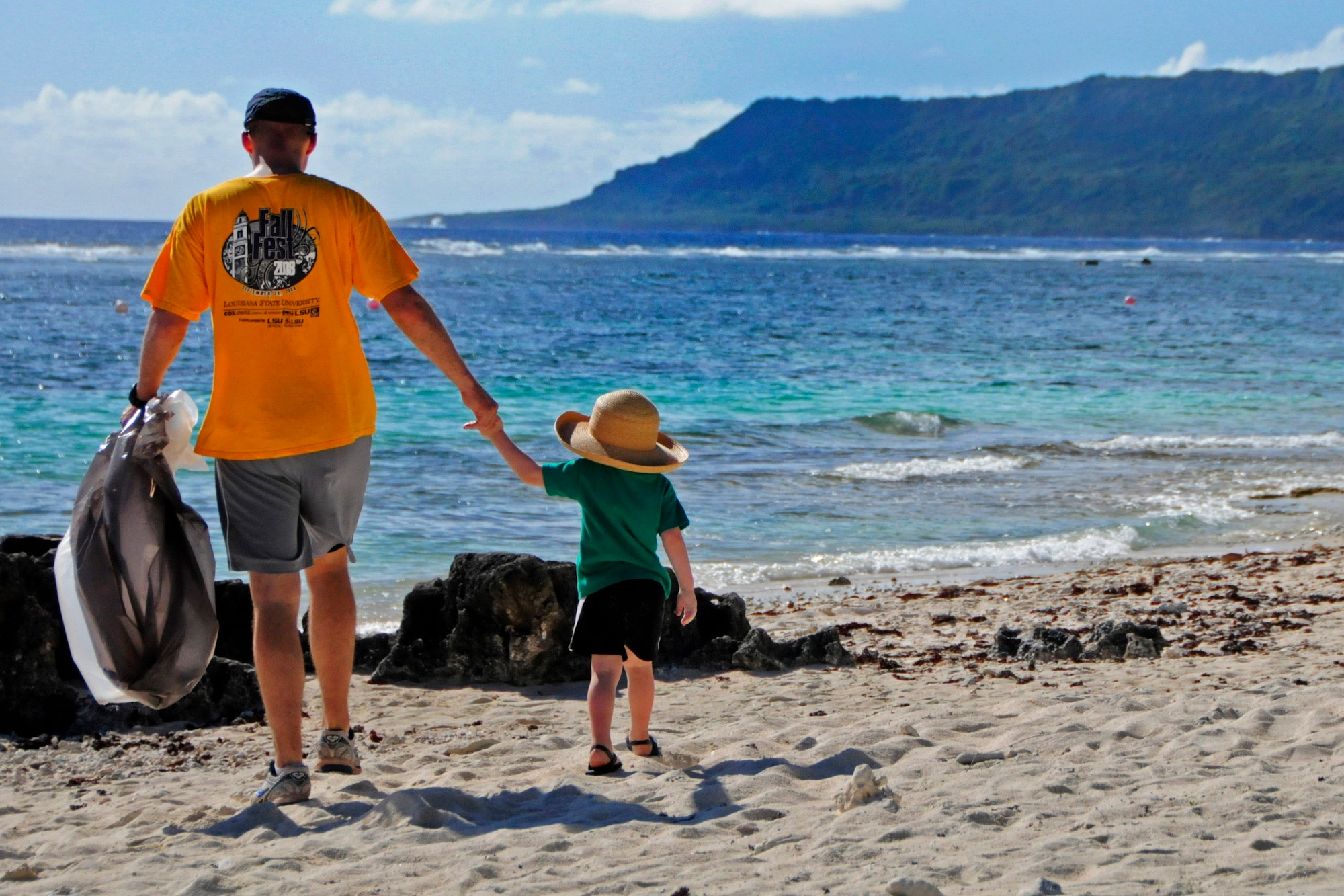 A volunteer and his son search for rubbish on the shore of Tarague Beach during the Earth Day cleanup at Andersen Air Force Base, Guam, April 21, 2013. Earth Day is an international event demonstrating the commitment and significant investment the United States and countries have made toward environmental security. (U.S. Air Force photo by Airman 1st Class Marianique Santos/Released)