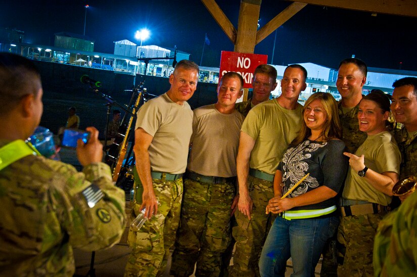 The Air Force Central Command Band “Vector” poses for a picture with a fan on The Boardwalk at Kandahar Airfield, Afghanistan, April 16, 2013. (U.S. Air Force photo/Senior Airman Scott Saldukas)