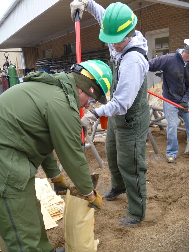 Members of the St. Louis District U.S. Army Corps of Engineers Flood Fight Team, David Israelitt and Chris Hopfinger assist each other in filling sandbags at Lock and Dam 24 in Clarksville, Mo., Apr. 19, 2013.  (U.S. Army Corps of Engineers photo)