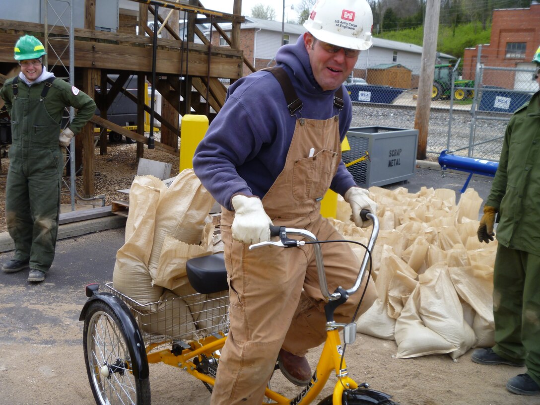St. Louis District, U.S. Army Corps of Engineers flood fight team member Scott Lussier, uses a bicycle to transport recently filled sandbags at Lock and Dam 24 in Clarksville, Mo., Apr. 19, 2013.  (U.S. Army Corps of Engineers photo)