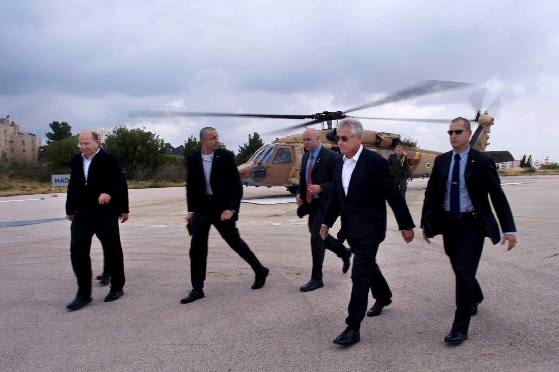 U.S. Defense Secretary Chuck Hagel, second from right, and Israeli Defense Minister Moshe Yaalon, left, exit an Israeli Black Hawk helicopter after touring the Golan Heights in Jerusalem, April 22, 2013. Hagel and Yaalon flew over the area that boarders Syria, which is in the midst of a civil war.