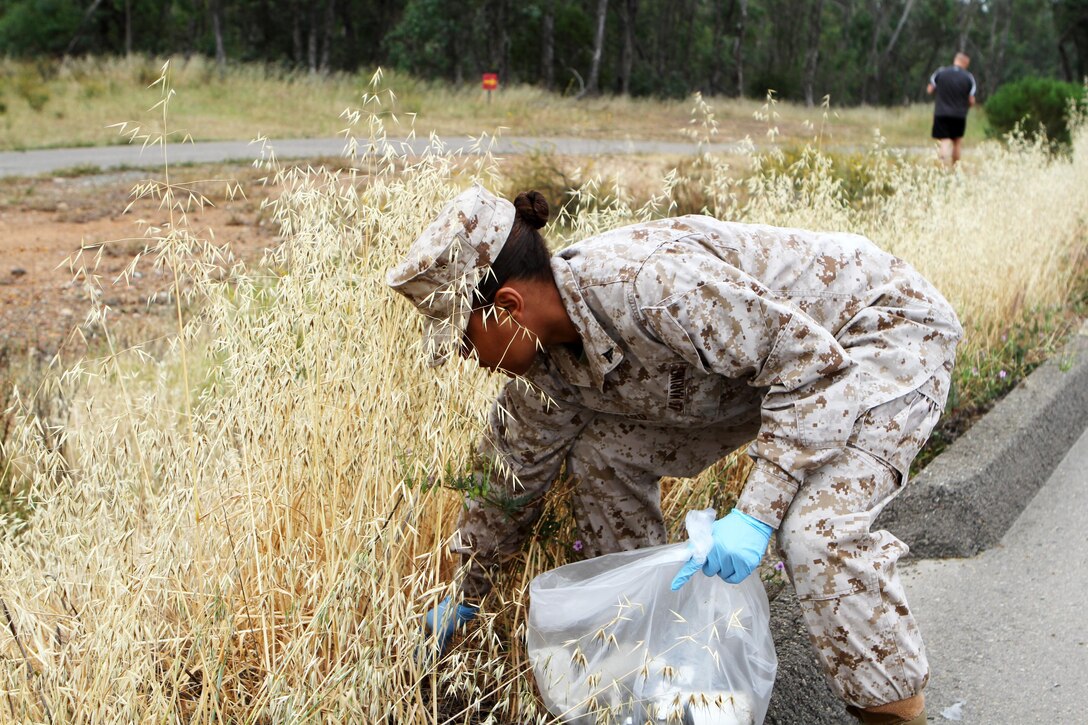 Lance Cpl. Brittane Woodard, an administrative specialist, joined other Headquarters and Headquarters Squadron Marines to clean up the physical fitness test route aboard Marine Corps Air Station Miramar, Calif., April 22. In honor of Earth Day, the Marines picked up trash along the route to ensure a clean and safe environment for future use.