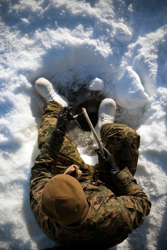 Cpl. Juarez Ordoniez, a ground communications organizational repairer with 4th Medical Battalion, 4th Marine Logistics Group, Marine Forces Reserve, sits in his snowy foxhole and ice fishes in the outskirts of Kotzebue, Alaska, April 17. Ordoniez, a native of Victorville, Calif., and a handful of other service members participating in Innovative Readiness Training Arctic Care 2013 were invited by the locals to ice fish. On his first try fishing, April 11, Ordoniez caught one sea fish, but this time he came out empty-handed.  