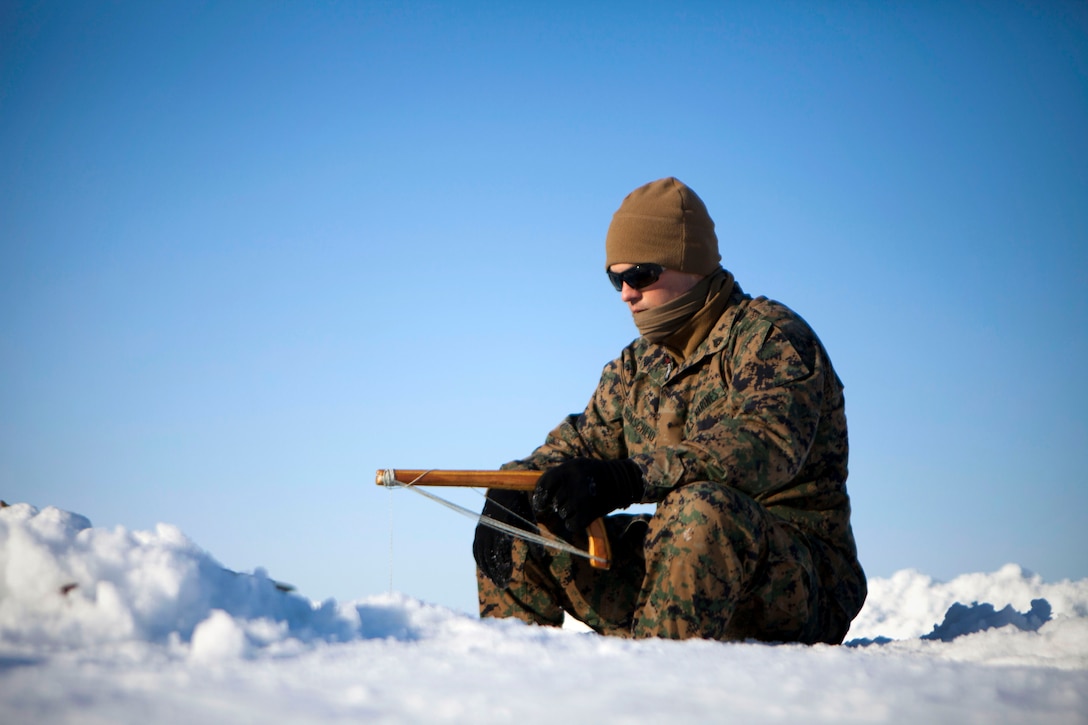 Cpl. Tyler Henscheid, a combat engineer with 4th Medical Battalion, 4th Marine Logistics Group, Marine Forces Reserve, ice fishes in the middle of Kotzebue Sound, April 17. Henscheid, a native of Westphalia, Iowa, and 11 other service members participating in Innovative Readiness Training Arctic Care 2013 spent nearly two hours trying to catch sea fish but came up empty-handed.  