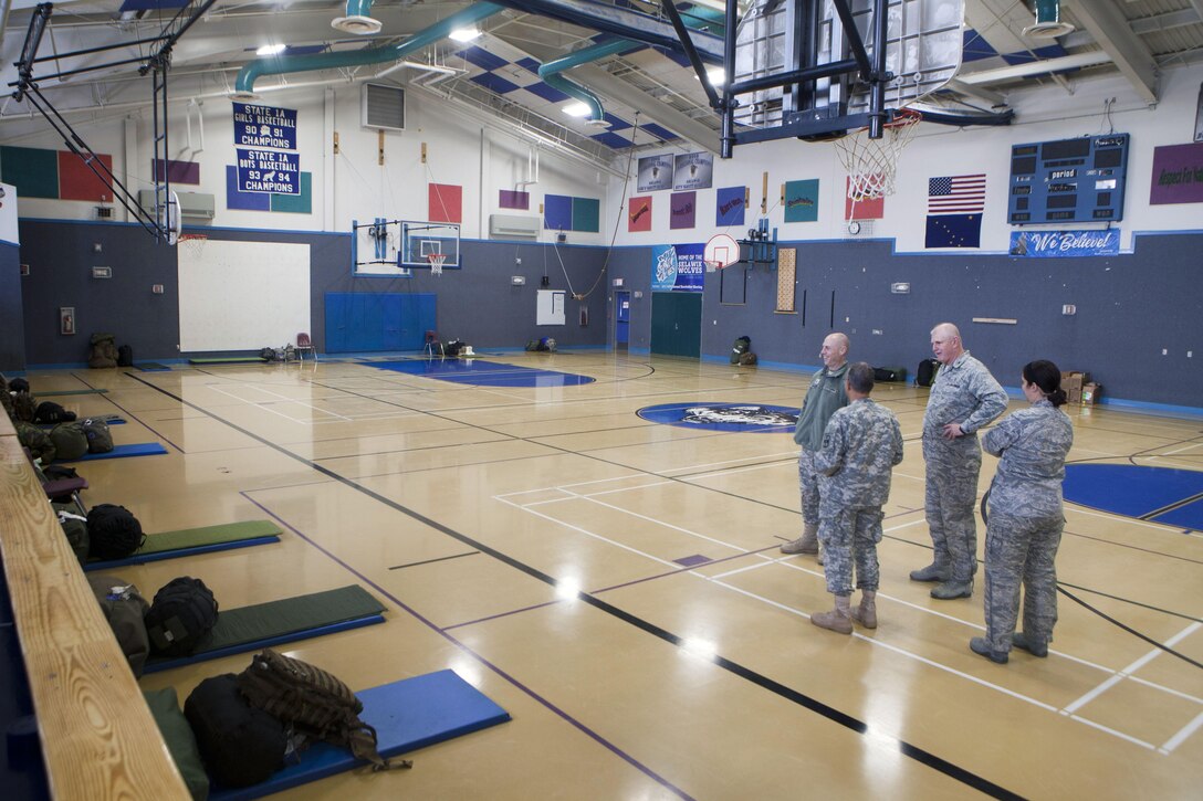 Brig. Gen. James Mason, deputy commander of operations for 807th Medical Command, Army Reserve, and other distinguished visitors look at a berthing area in the Selawik School, April 20. Service members participating in Innovative Readiness Training Arctic Care 2013 have to sleep in makeshift berthing areas whenever they travel to a remote village as part of their training. IRT Arctic Care is a multi-service humanitarian and training program that focuses on enhancing the capability of U.S. forces in peacetime support operations, humanitarian assistance and disaster relief. IRT Arctic Care brings medical, dental and veterinary aid to 12 rural villages in Alaska. The exercise is primarily a Reserve effort with Marine Forces Reserve taking the lead and receiving logistical and medical support from the National Guard, Army Reserve, Navy Reserve and Air Force Reserve.
