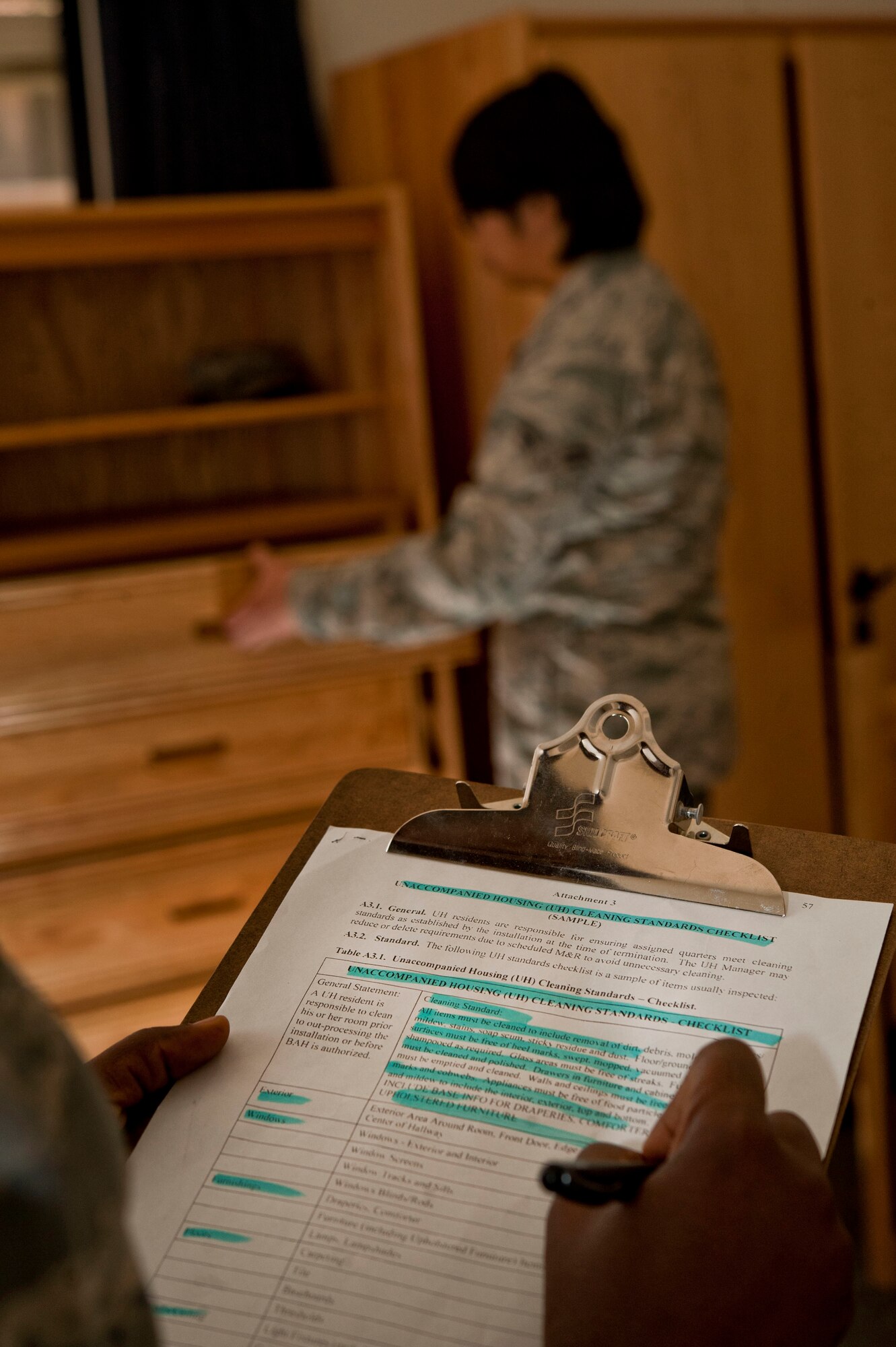 A dorm manager from the 99th Civil Engineer Squadron conducts a final inspection on a dorm room April 22, 2013, at Nellis Air Force Base, Nev. Airmen moving out of the dorms must complete a room inspection before being signed out of the dorms, which is the last item on the out processing checklist. (U.S. Air Force photo by Senior Airman Daniel Hughes)