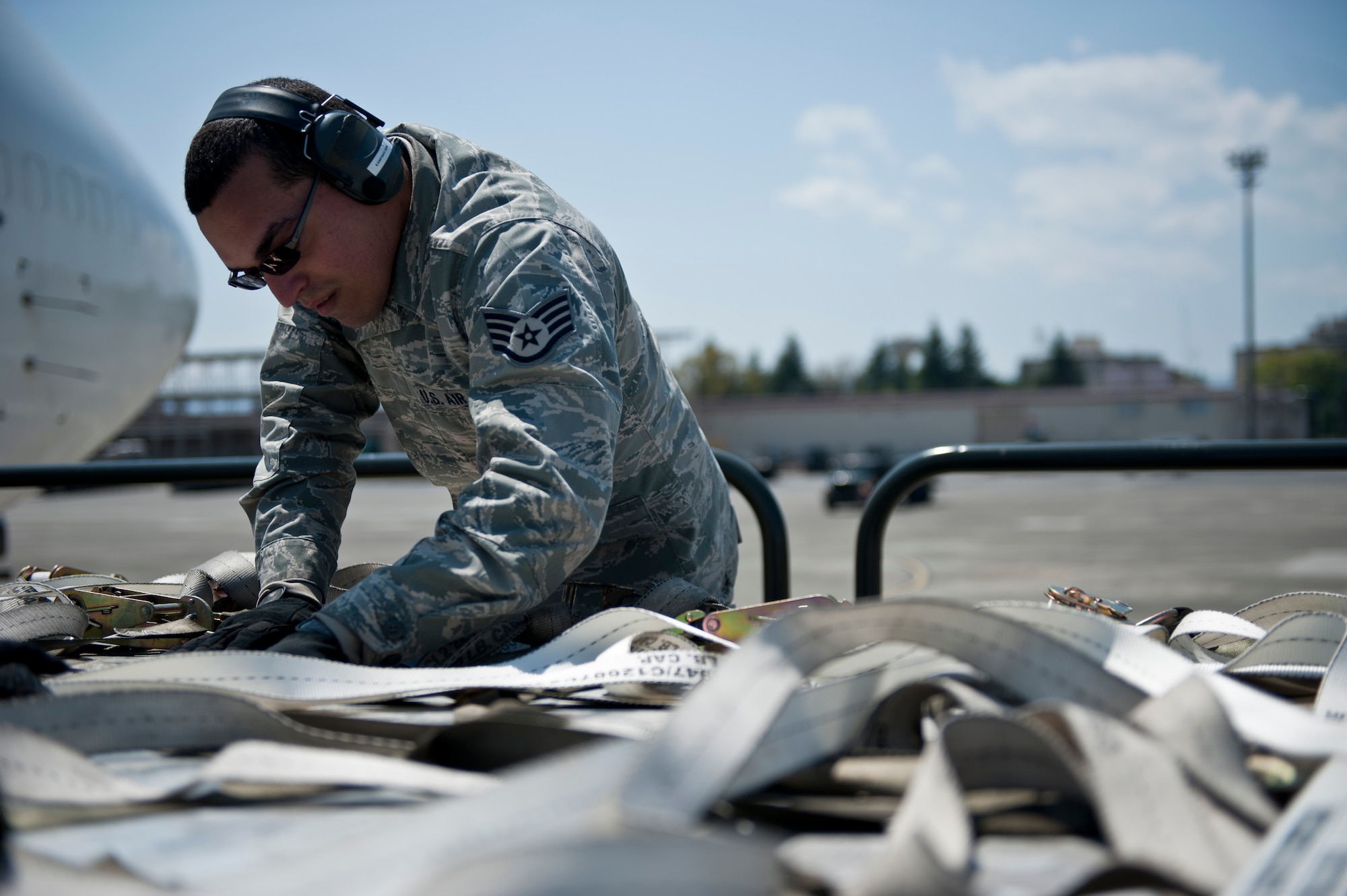 YOKOTA AIR BASE, Japan -- Staff Sgt. Eliezer Santiago, 730th Ramp Services Supervisor, works to undo straps around cargo at Yokota Air Base, Japan, April 22, 2013.  One of the duties of ramp services is to unload cargo and bring it to cargo processing. (U.S. Air Force photo by Airman 1st Class Meagan Schutter/Released)